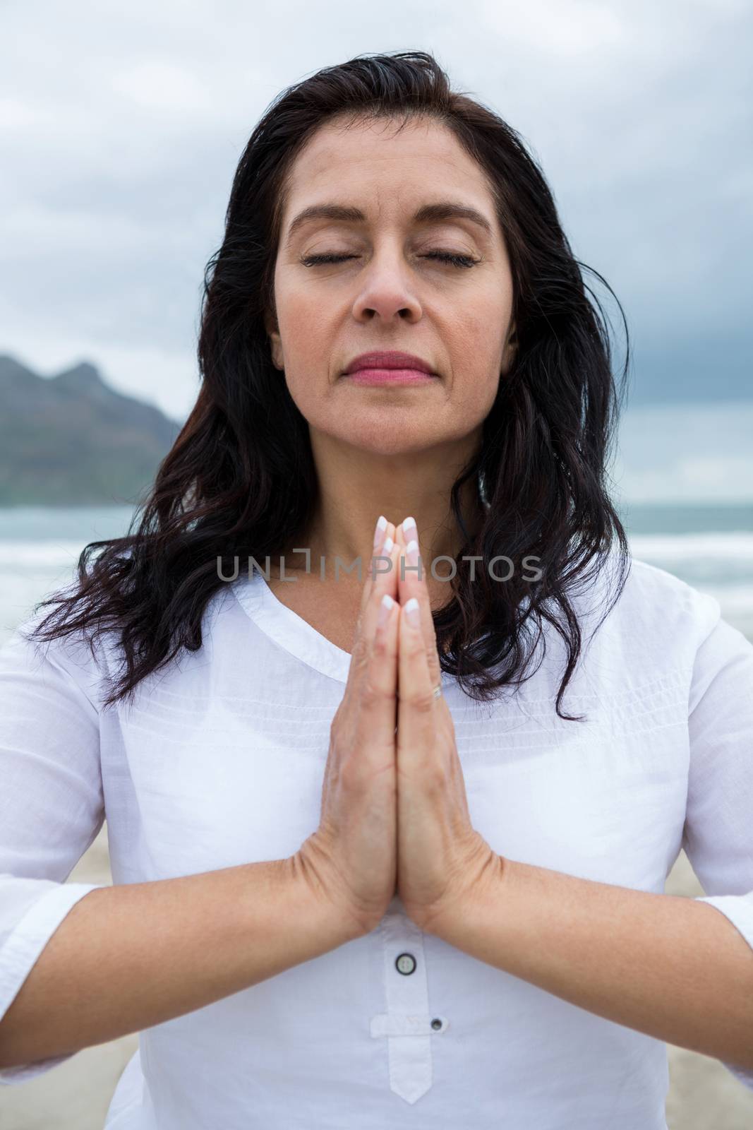 Woman performing yoga on beach during winter