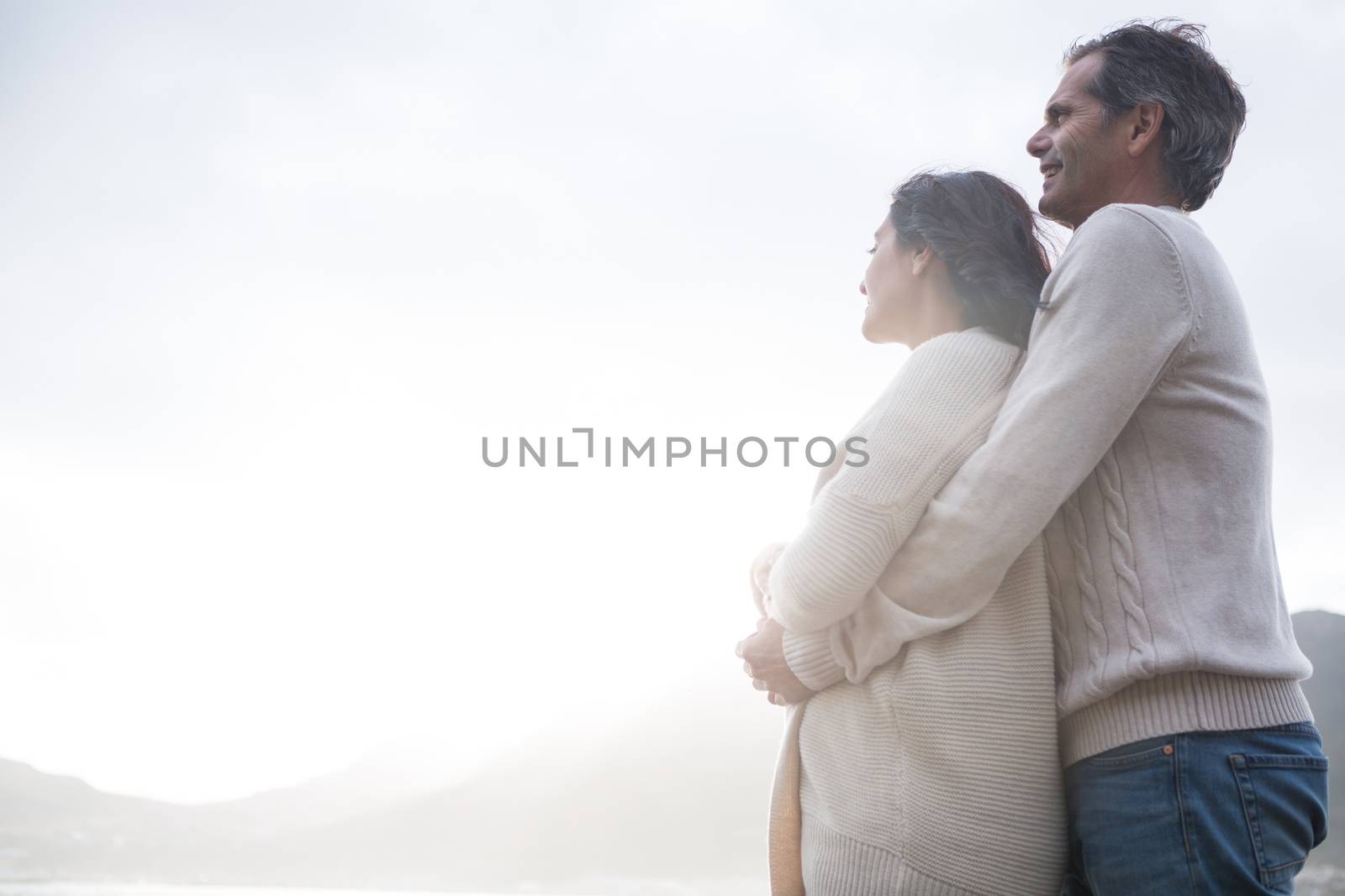 Romantic couple embracing each other on beach by Wavebreakmedia