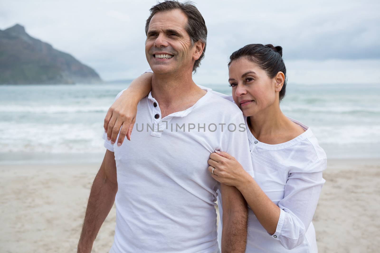 Romantic couple standing on beach during winter