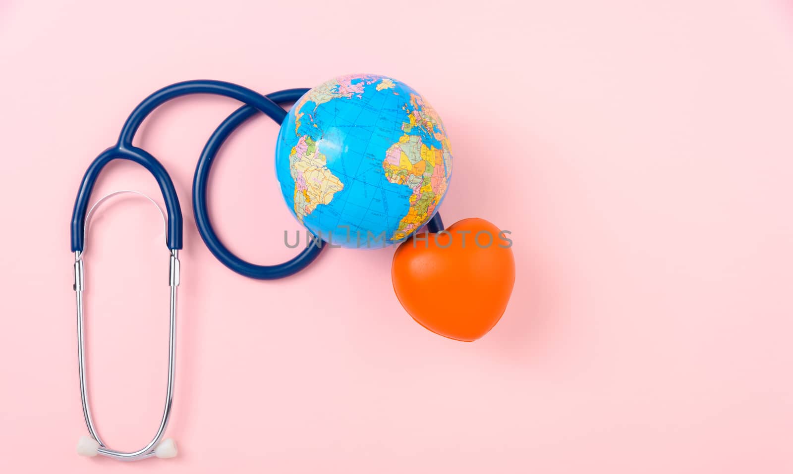 World health day concept, Stethoscope, globe and red heart on pink background with copy space. Global health care