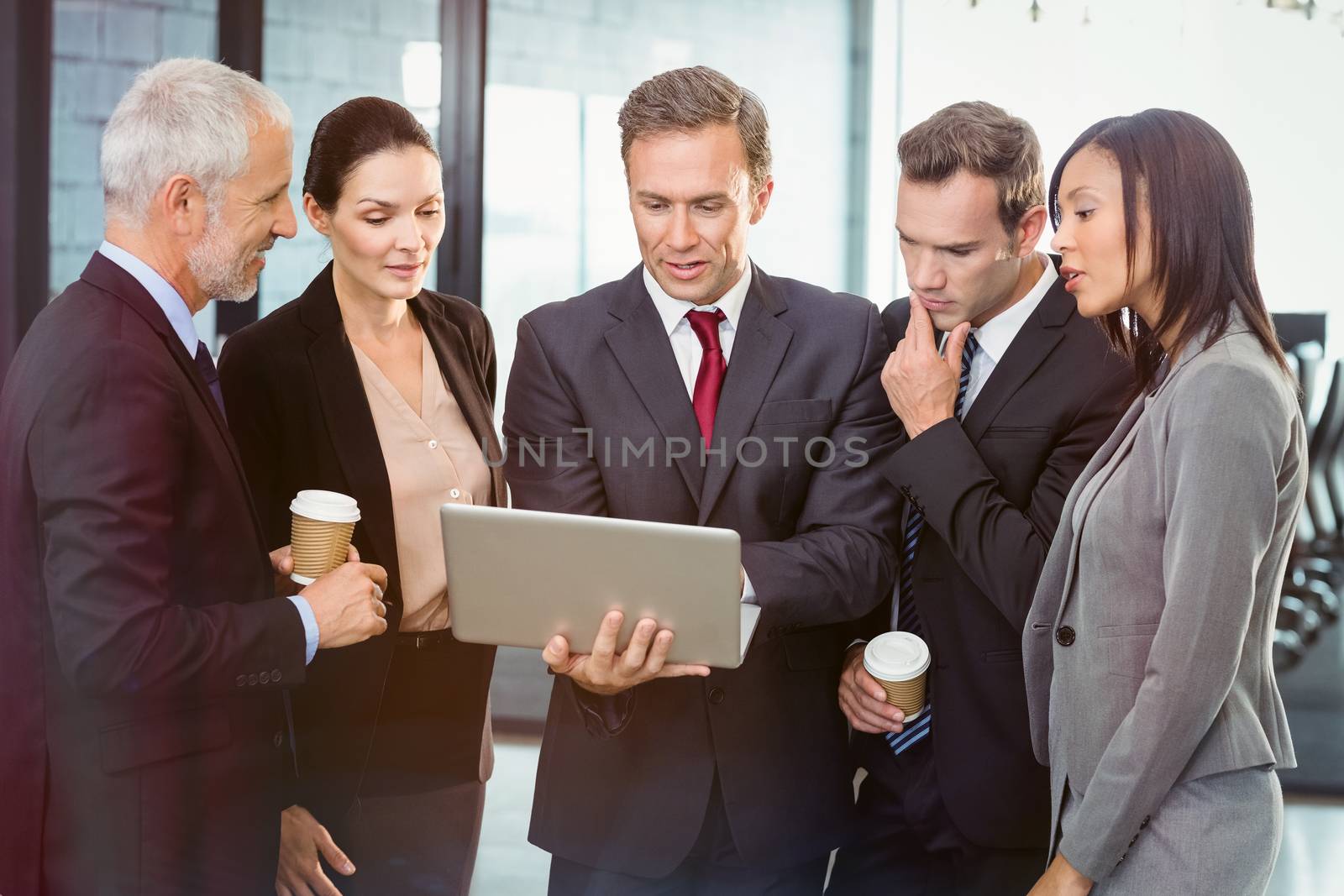 Business people looking at laptop in office