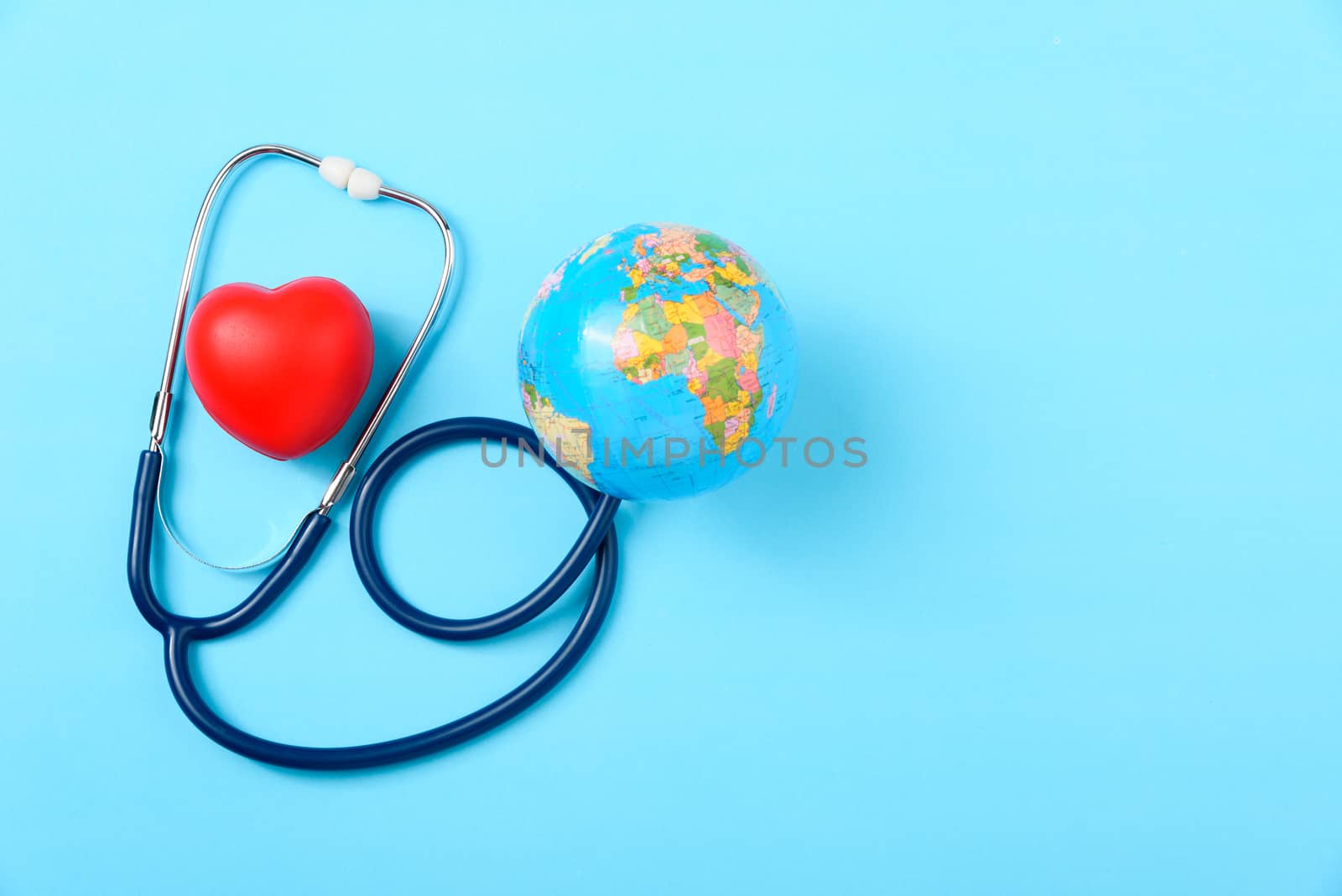 World health day concept, Stethoscope, globe and red heart on blue background with copy space. Global health care