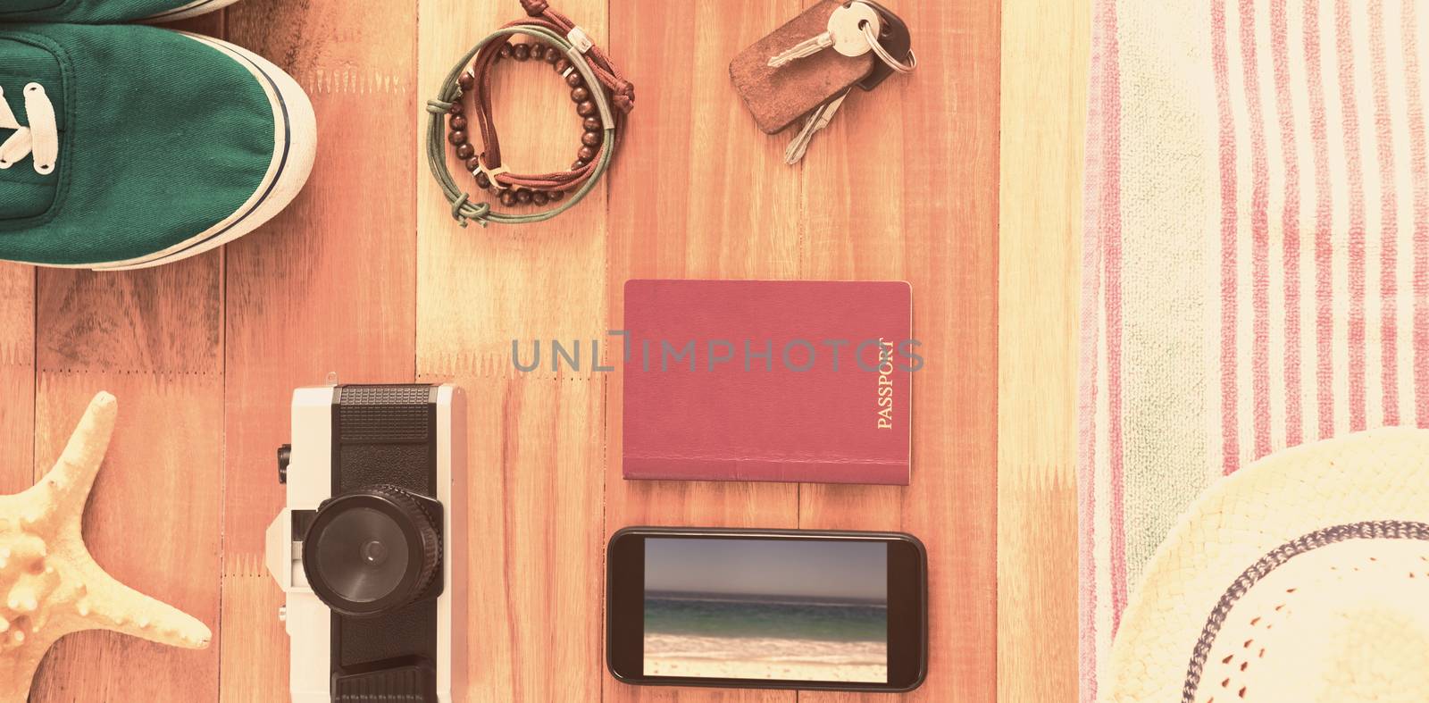 Accessories and travel items on wooden board against waters edge at the beach