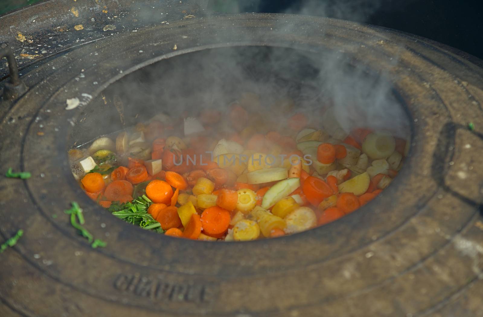 Medieval style cooking of various vegetables in big metal pot