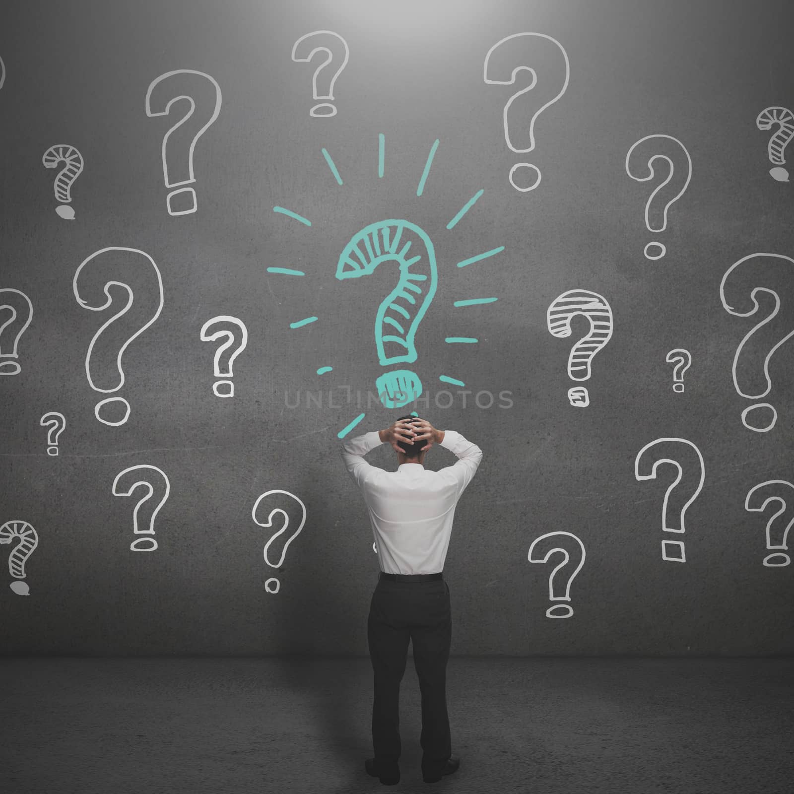 Anxious businessman looking at a drawing of question marks