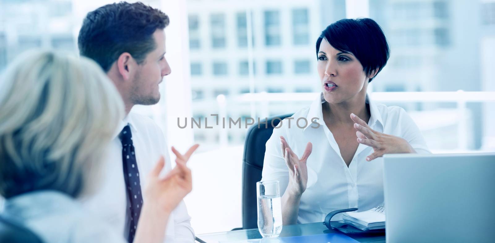 Young well dressed business people in discussion at a bright office