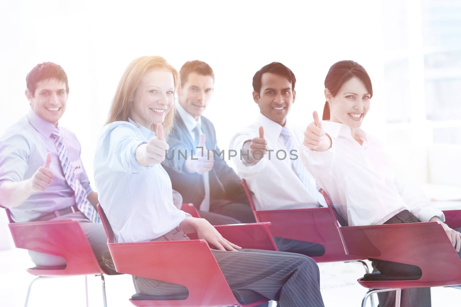 Business people with thumbs up at a conference by Wavebreakmedia