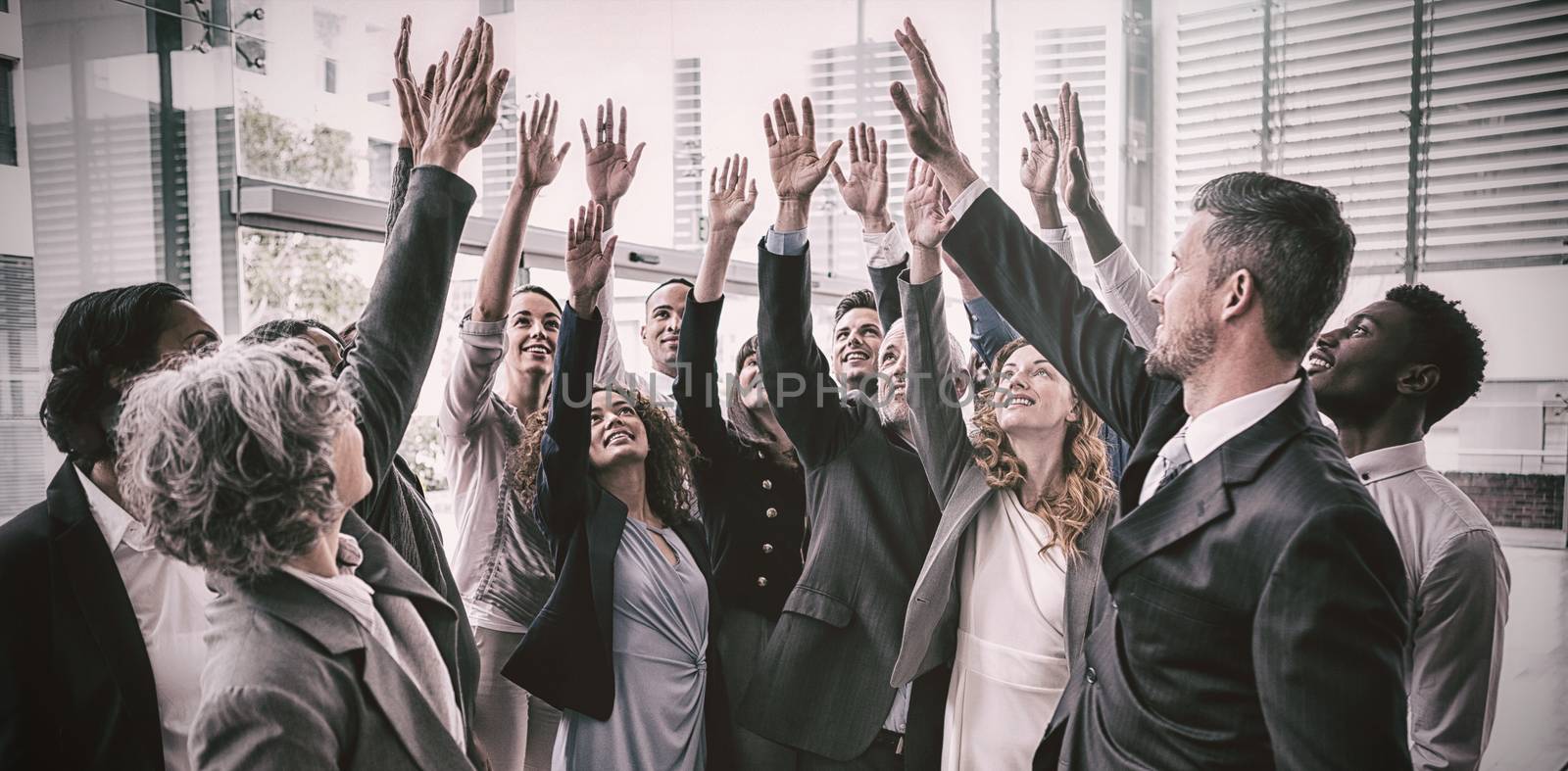 Business people raising their arms during meeting in office