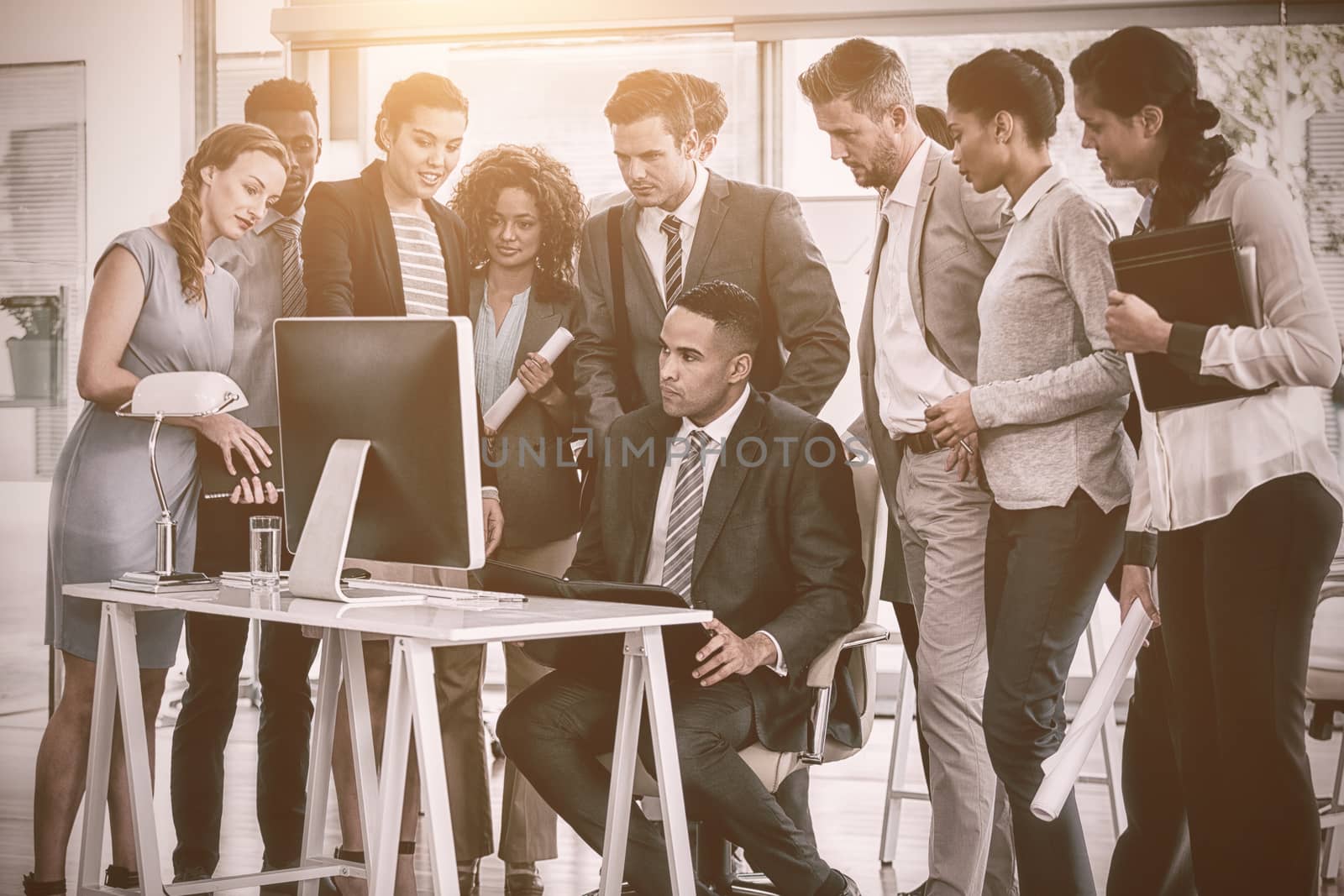 Focsed business people looking into computer in office