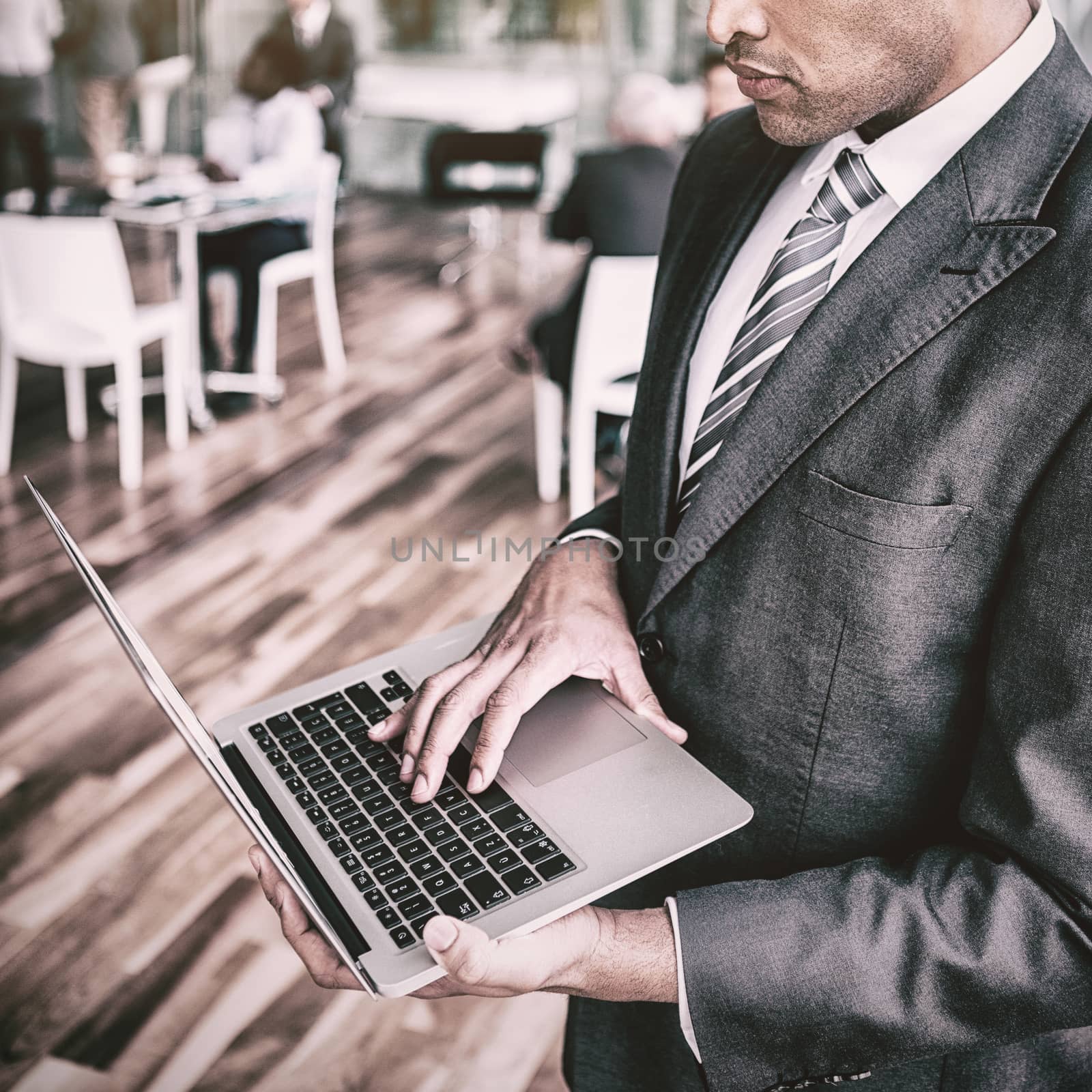Focused businessman using laptop while standing in office