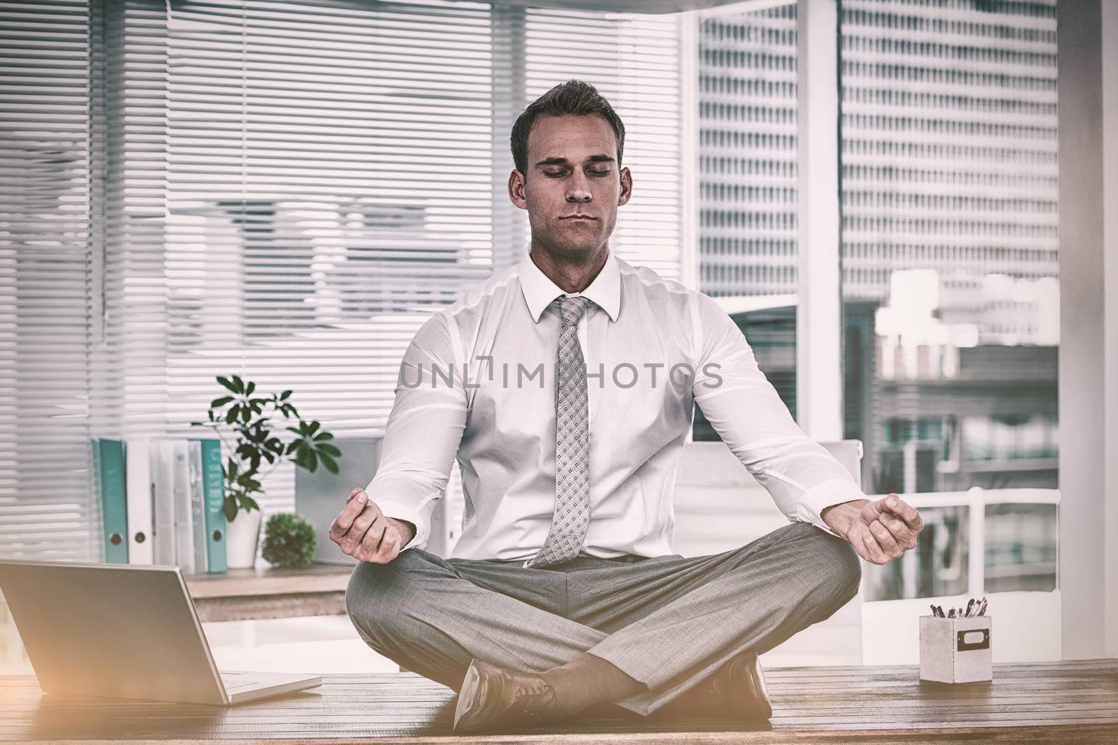 Zen businessman doing yoga meditation  by Wavebreakmedia