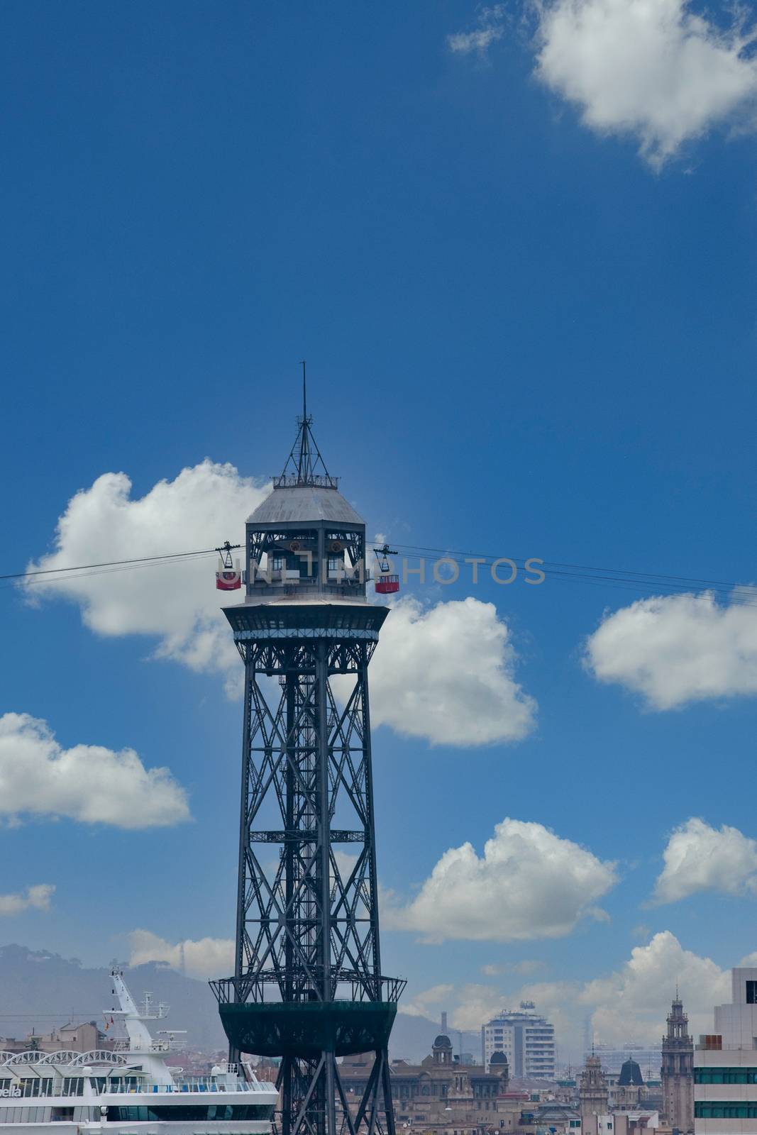 A skylift with two cars against a  cloudy sky in Barcelona Spain