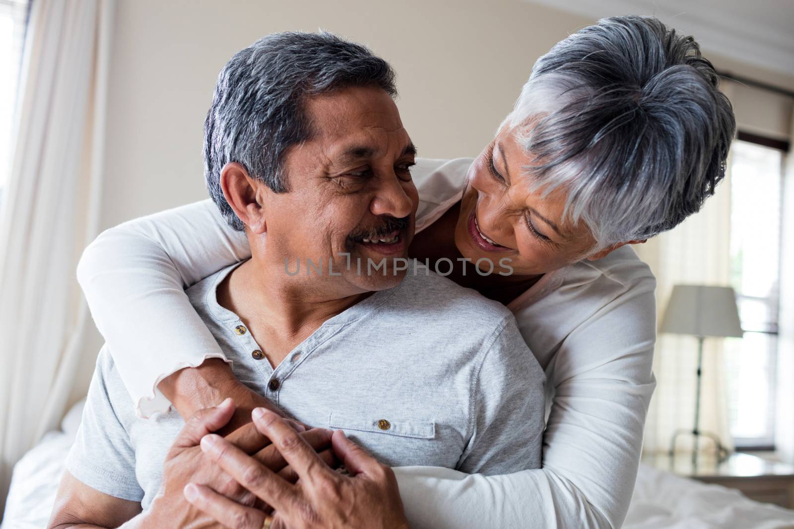 Romantic couple embracing in bedroom at home