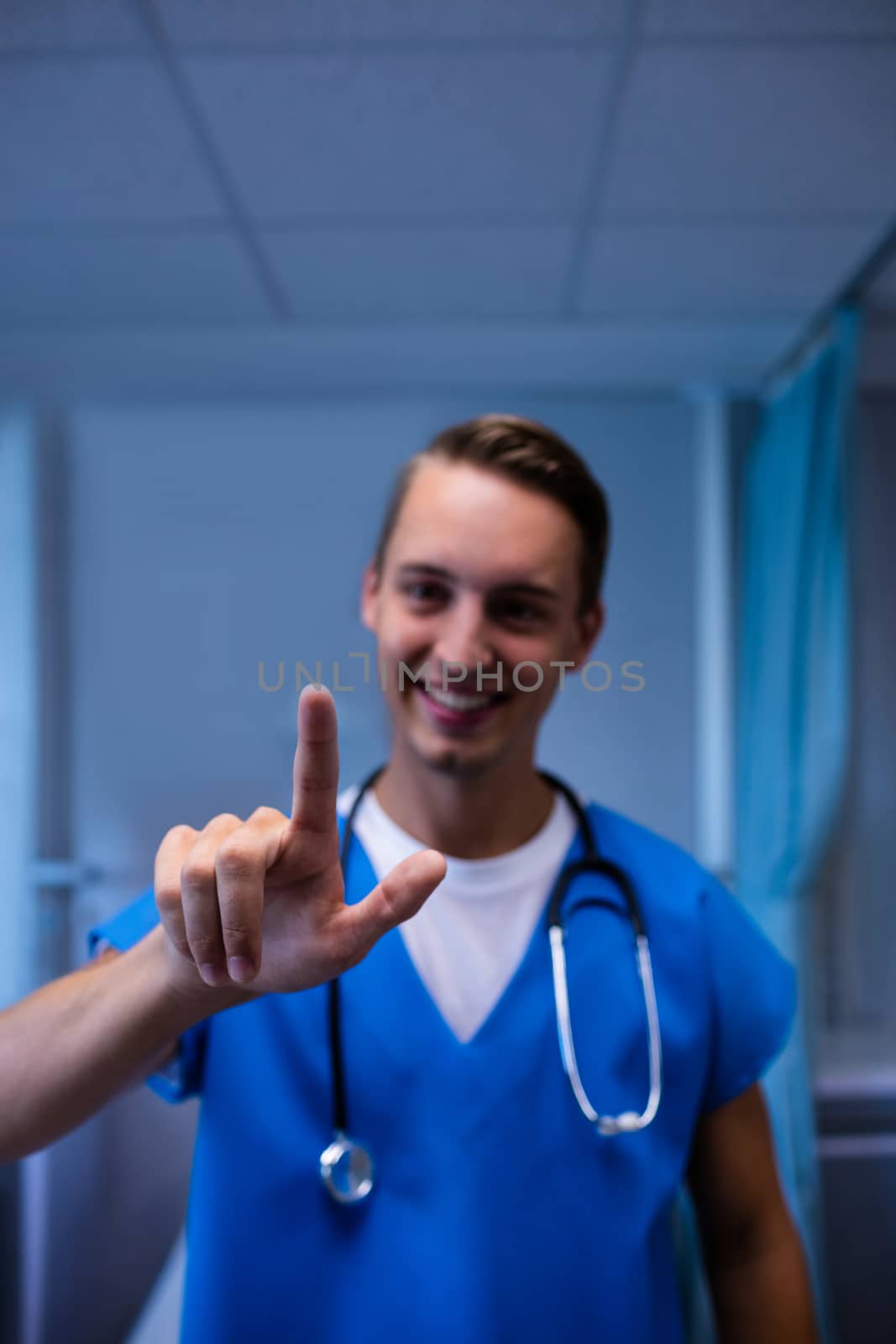 Portrait of smiling doctor gesturing in ward at hospital