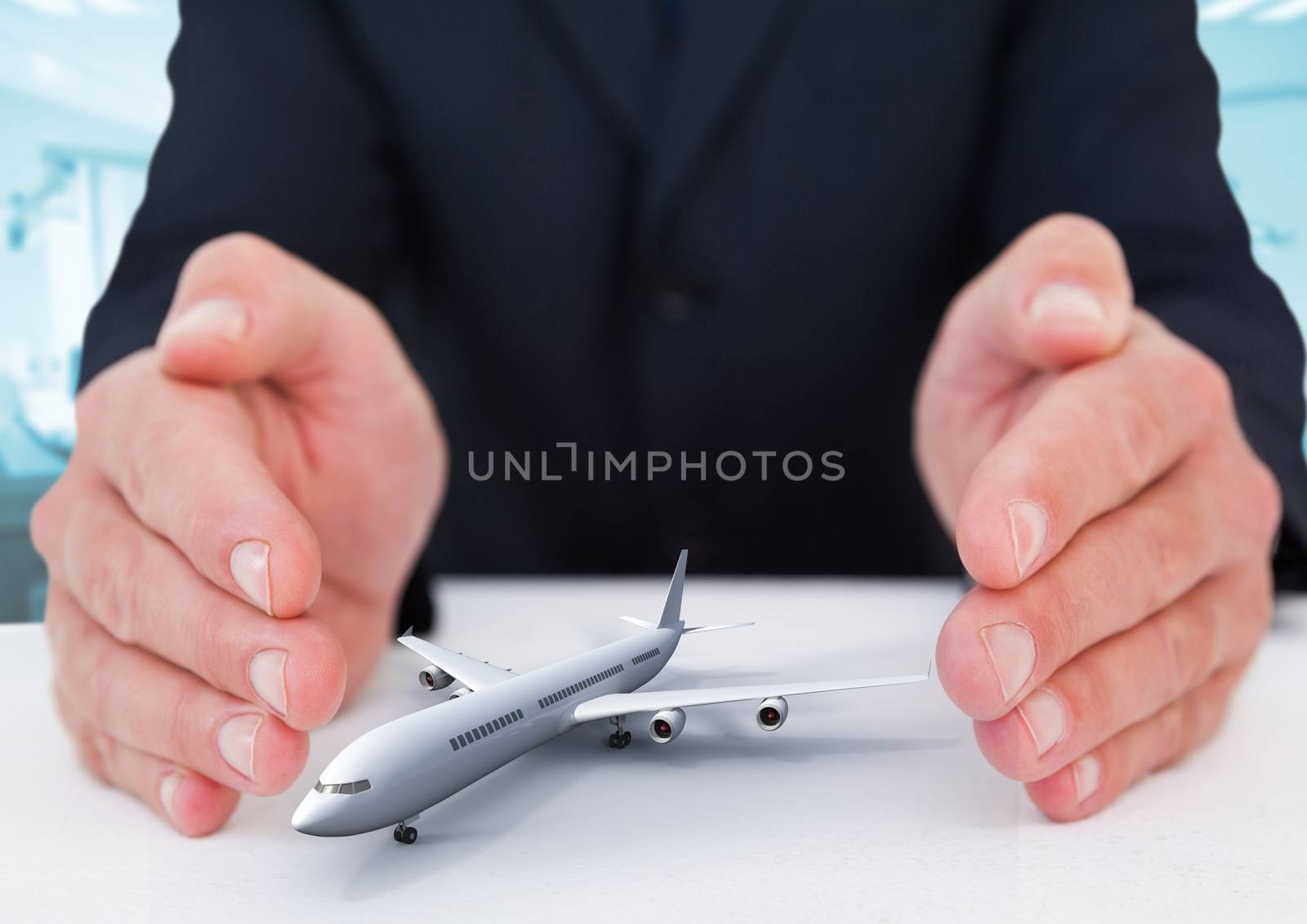 Airplane model surrounded by hands in gesture of protection by Wavebreakmedia