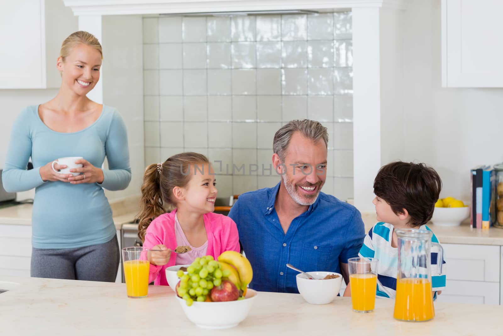 Happy family having breakfast in kitchen by Wavebreakmedia