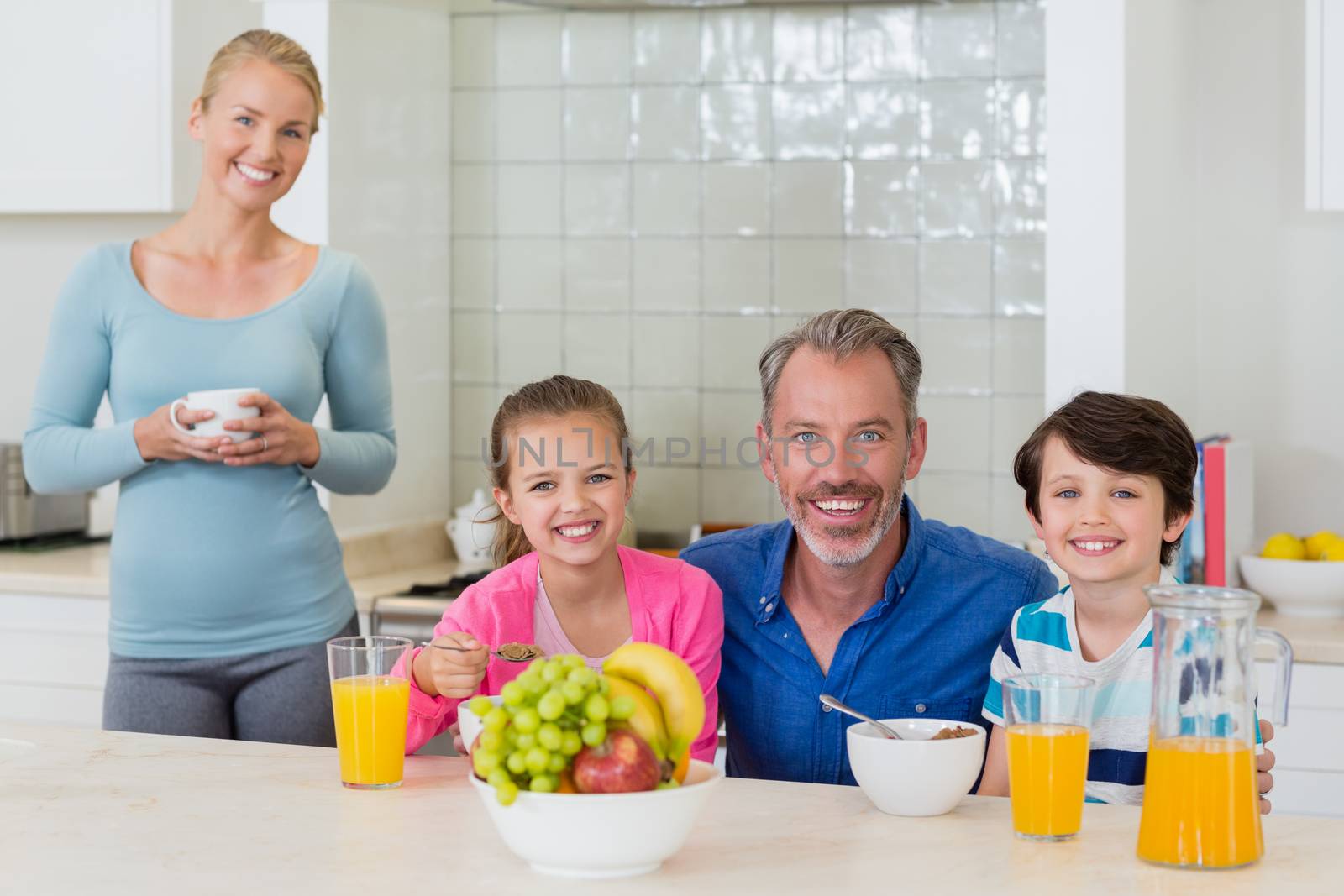 Happy family having breakfast in kitchen by Wavebreakmedia