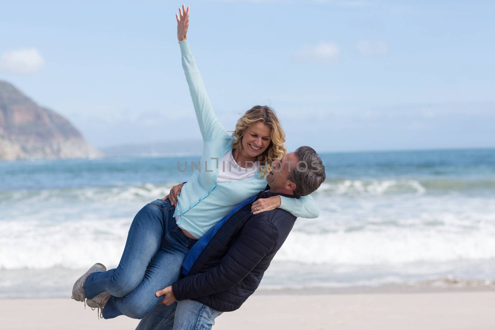 Mature couple enjoying on the beach by Wavebreakmedia