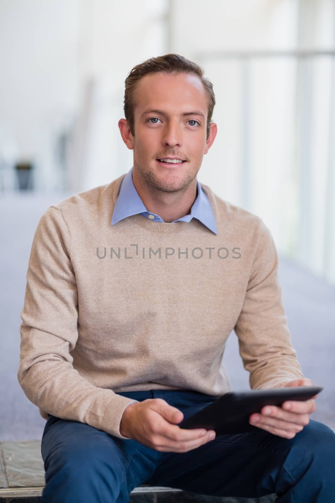 Portrait of a businessman holding digital tablet at conference centre