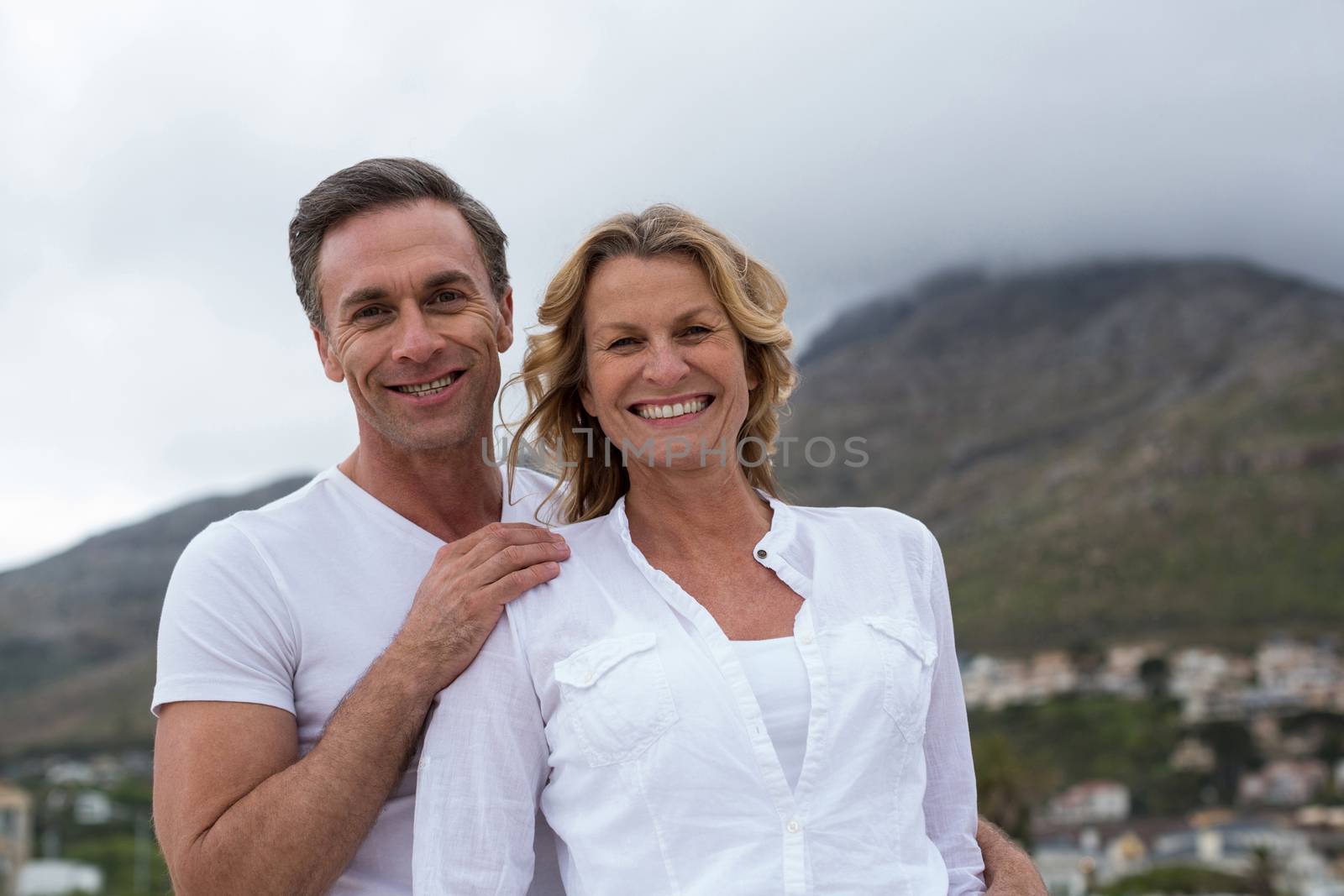 Mature couple standing together on the beach by Wavebreakmedia