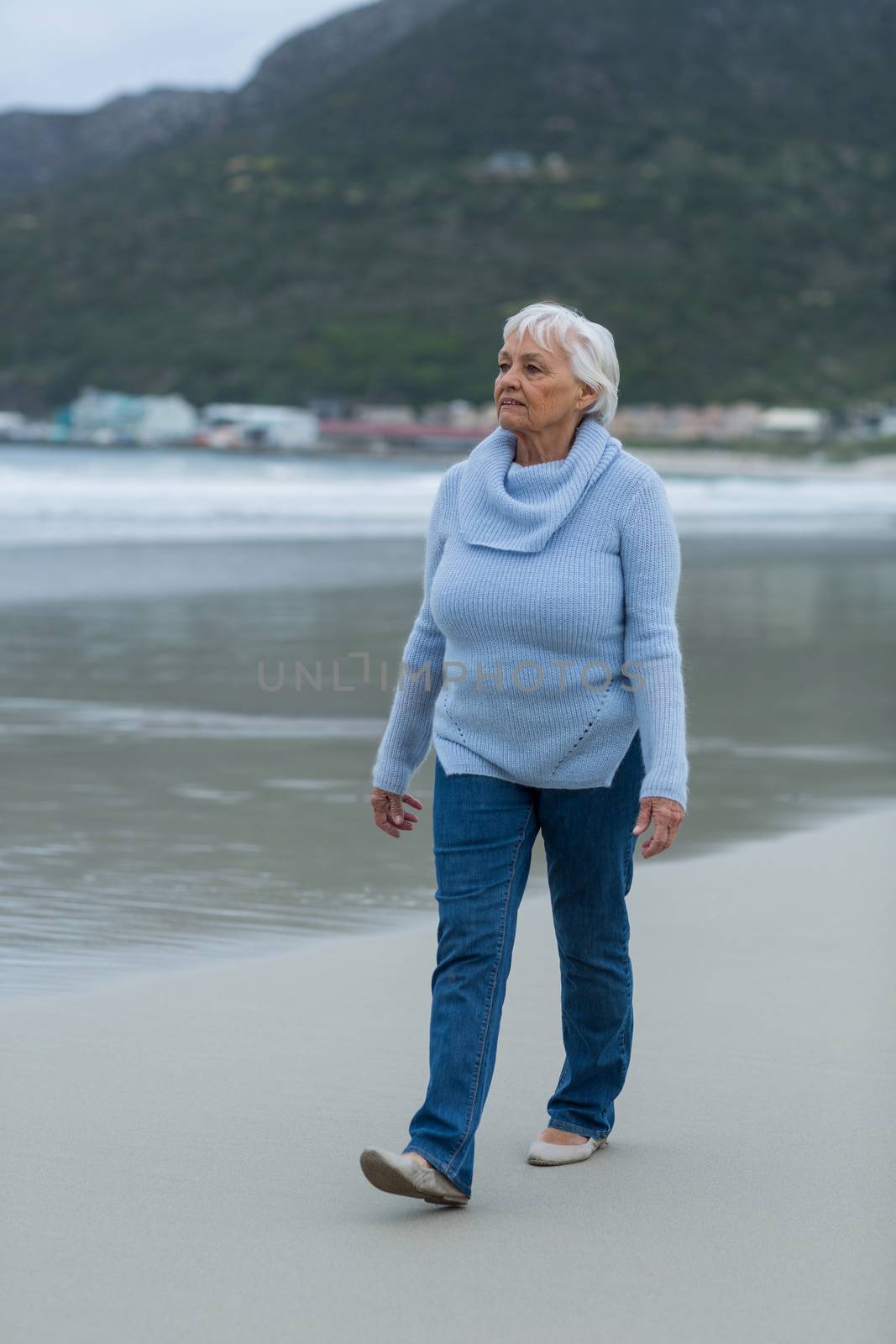 Senior woman walking on the beach by Wavebreakmedia