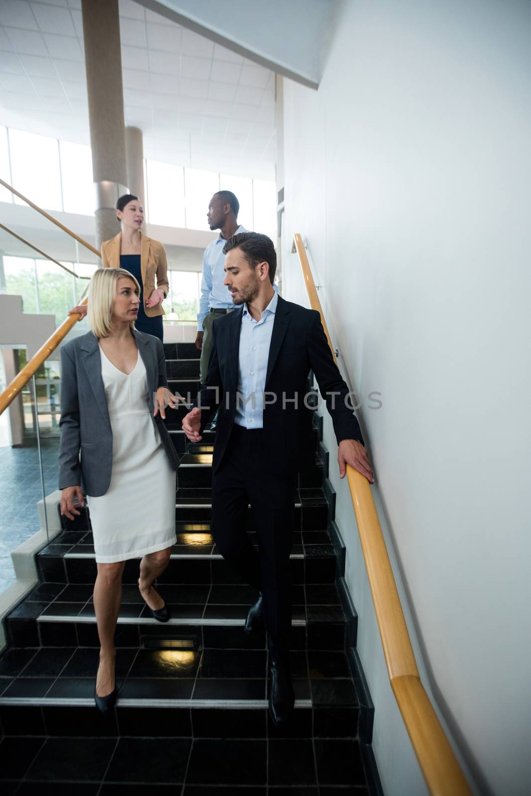 Business executives walking down the stairs by Wavebreakmedia