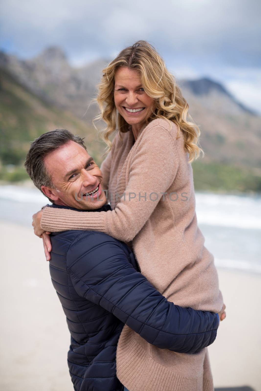 Mature man holding mature woman on beach by Wavebreakmedia