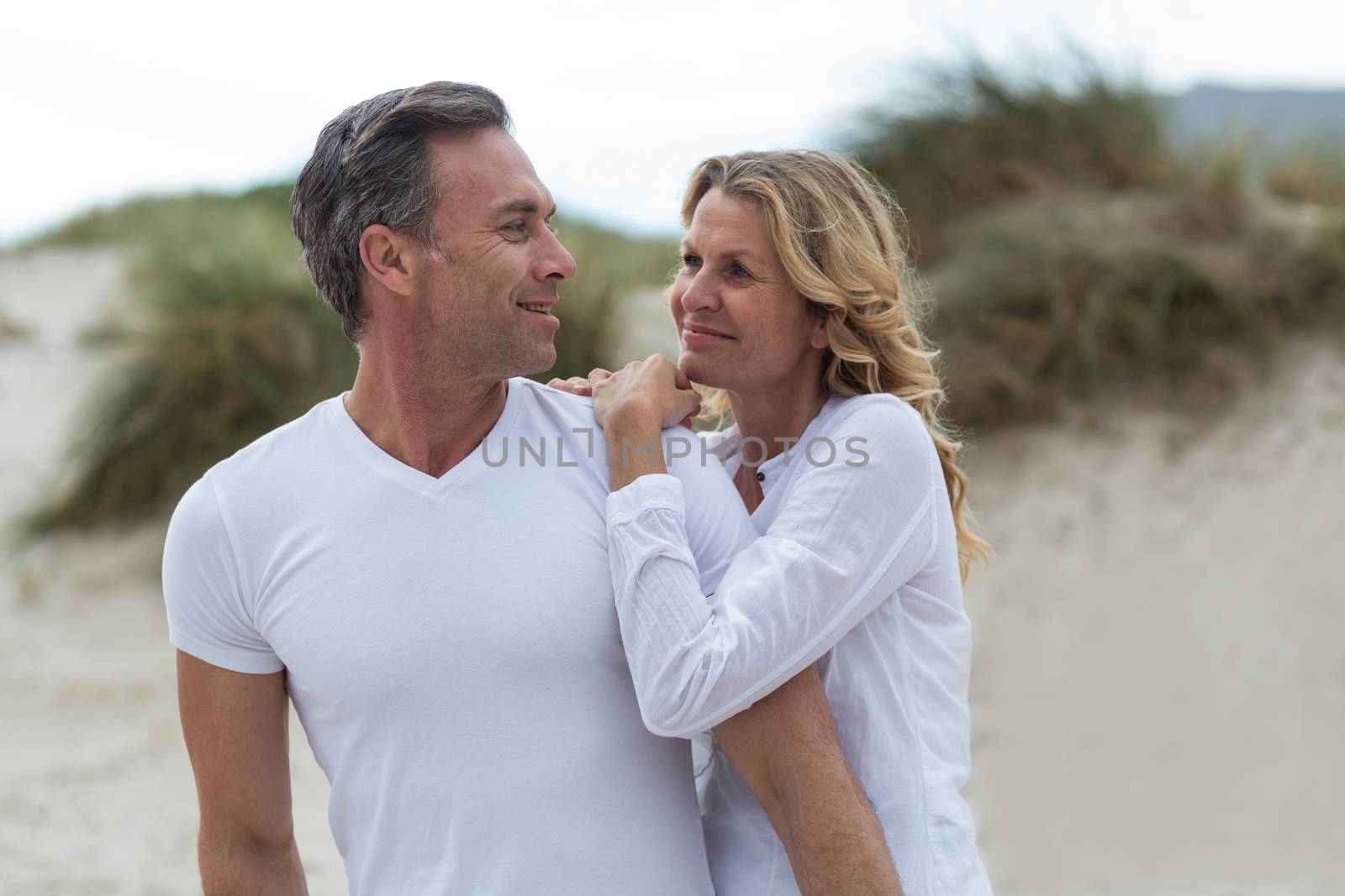 Mature couple standing together on the beach by Wavebreakmedia