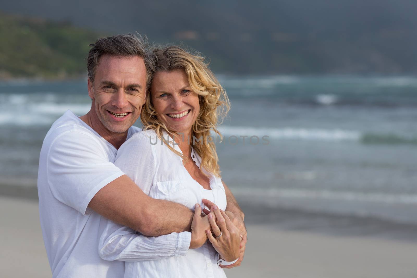 Mature couple embracing each other on the beach by Wavebreakmedia