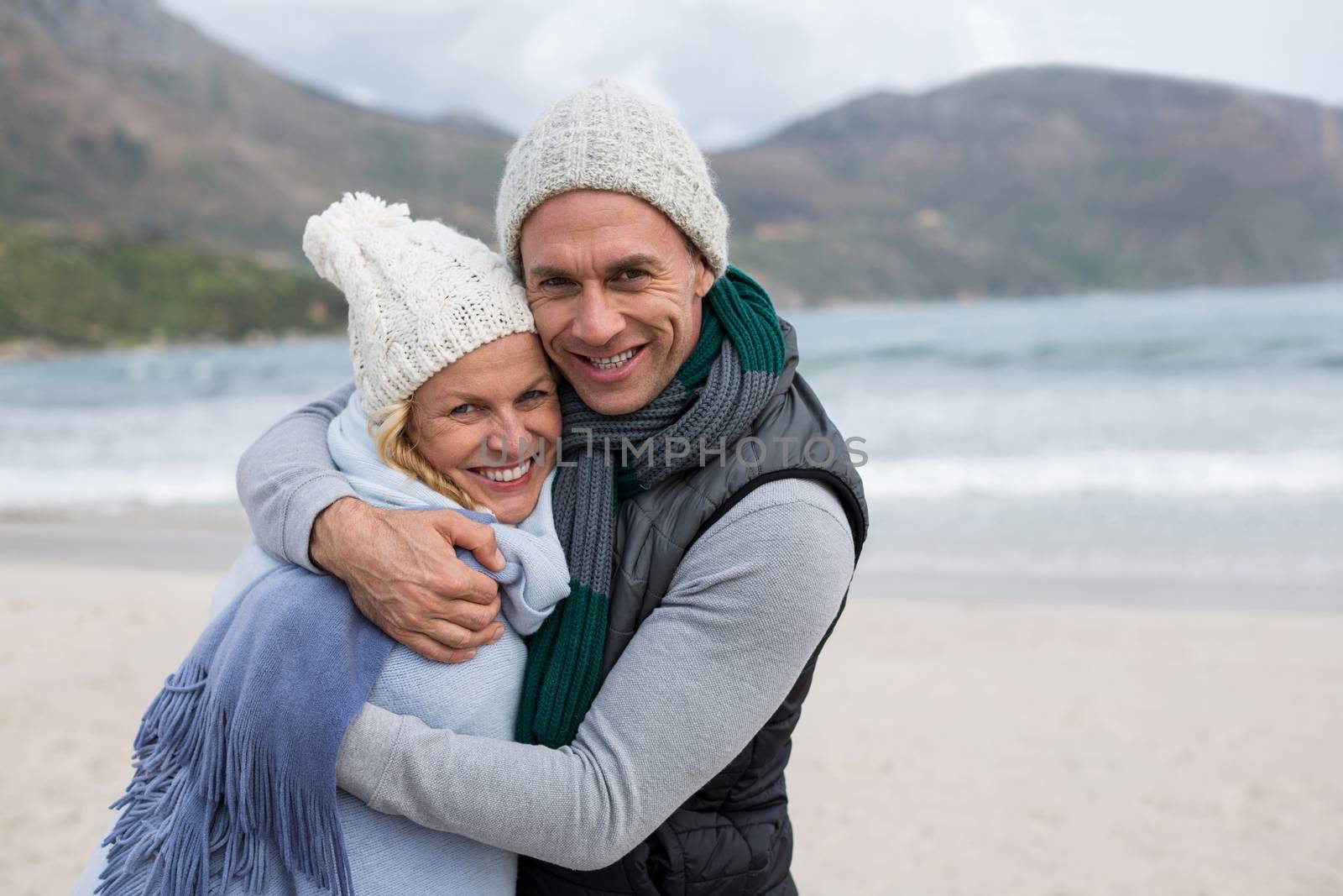 Mature couple embracing each other on the beach by Wavebreakmedia