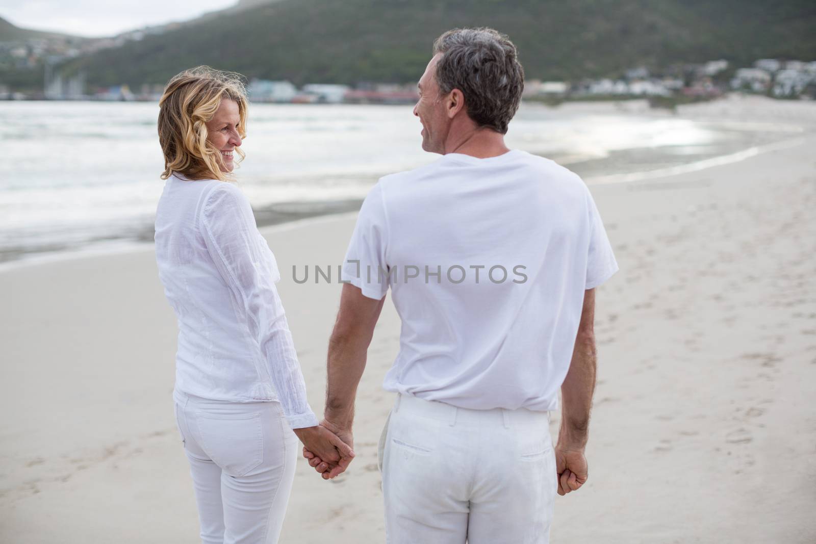 Couple standing with holding hands on the beach by Wavebreakmedia