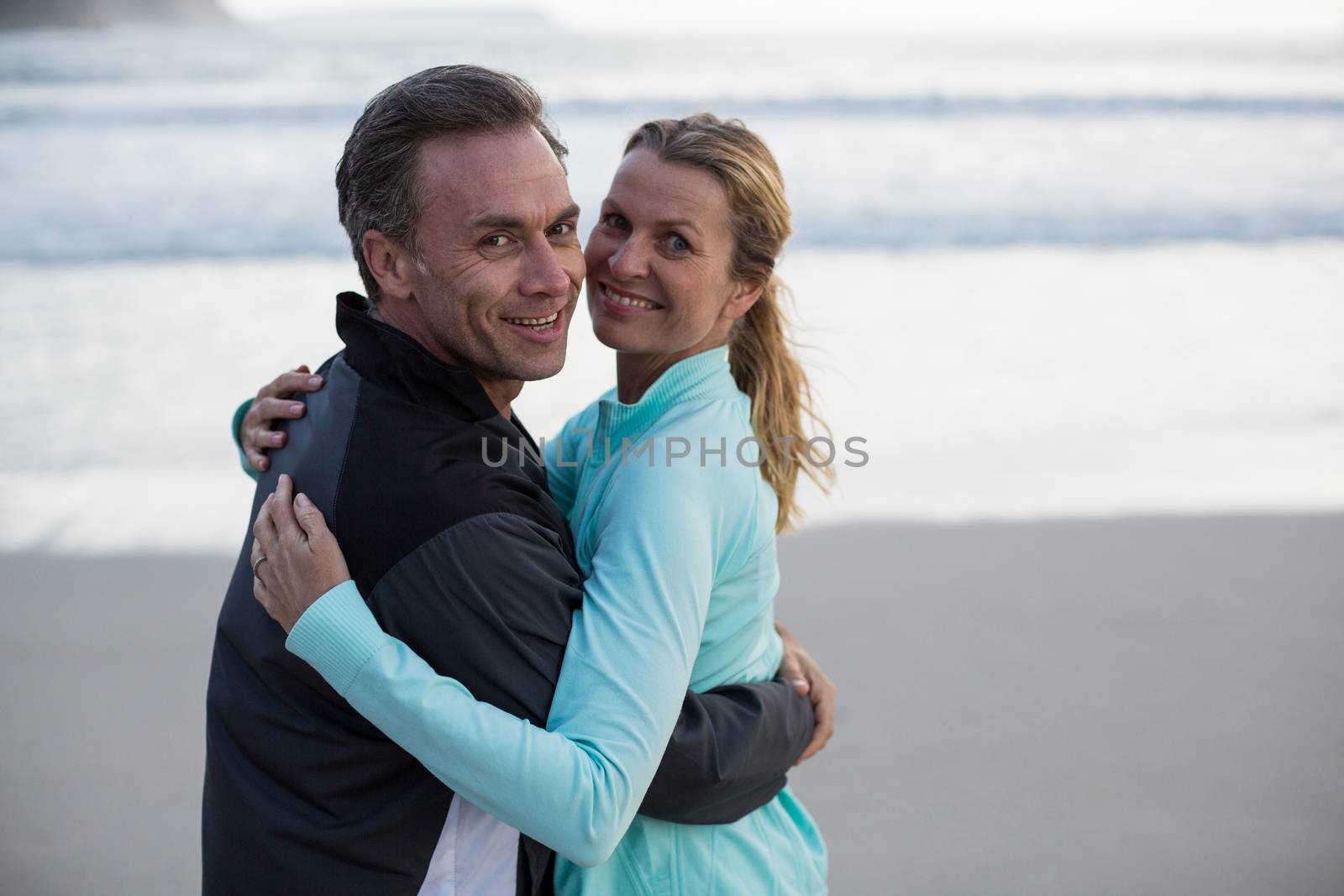 Mature couple embracing each other on the beach by Wavebreakmedia