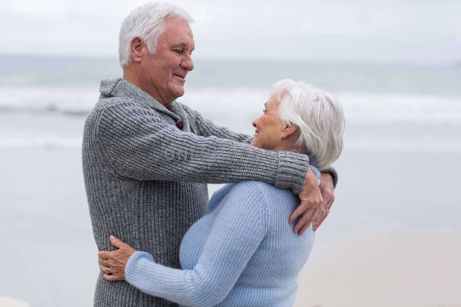 Romantic senior couple standing together on the beach