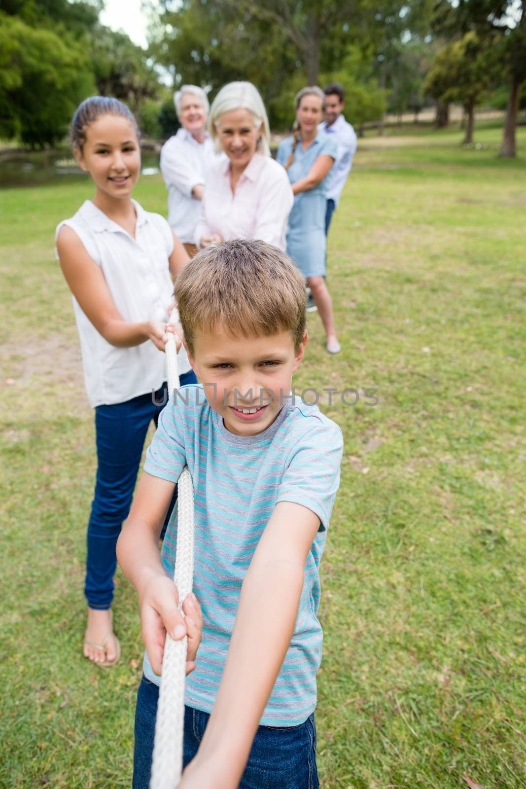 Multi-generation family pulling a rope in tug of war by Wavebreakmedia