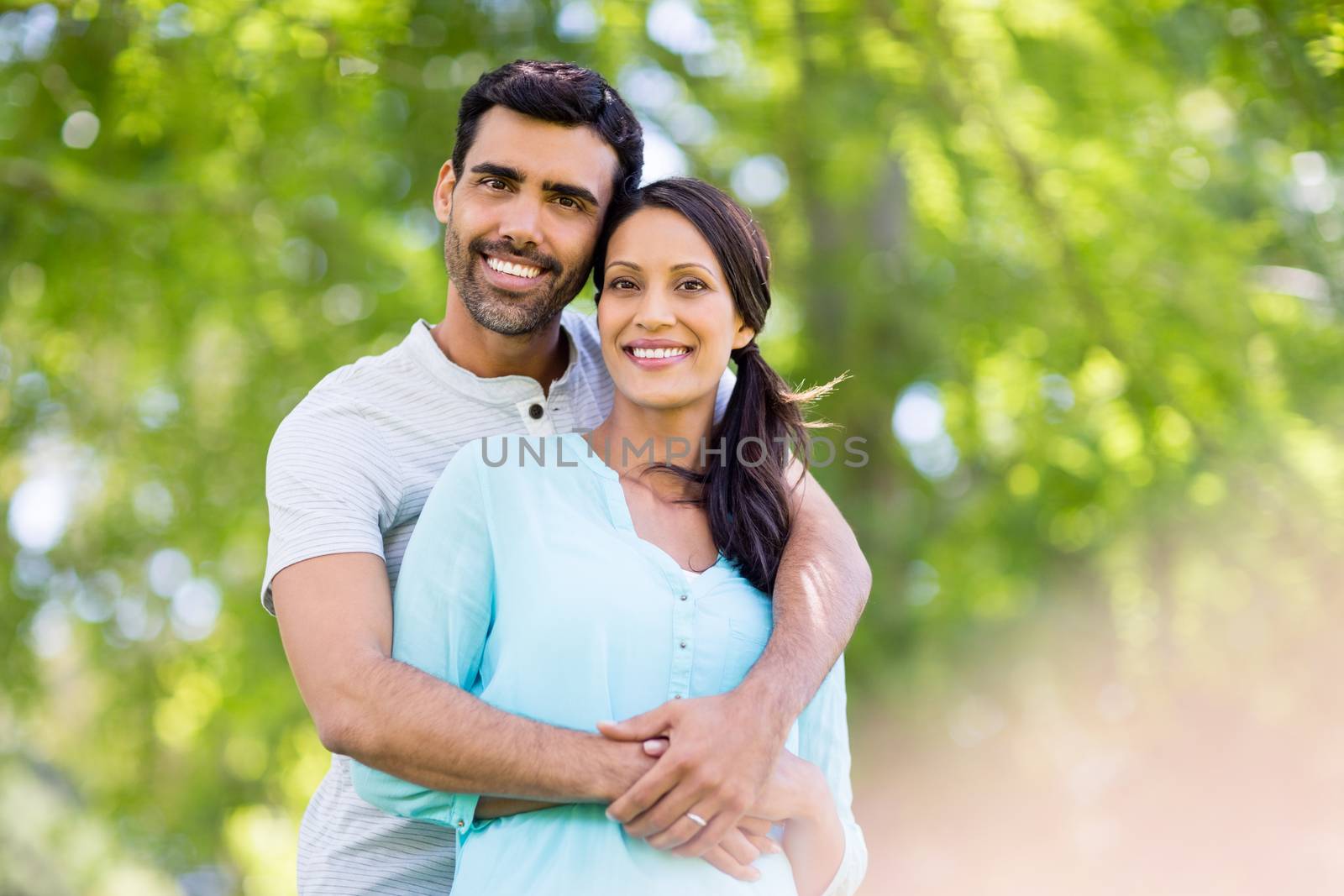 Portrait of romantic couple embracing each other in park