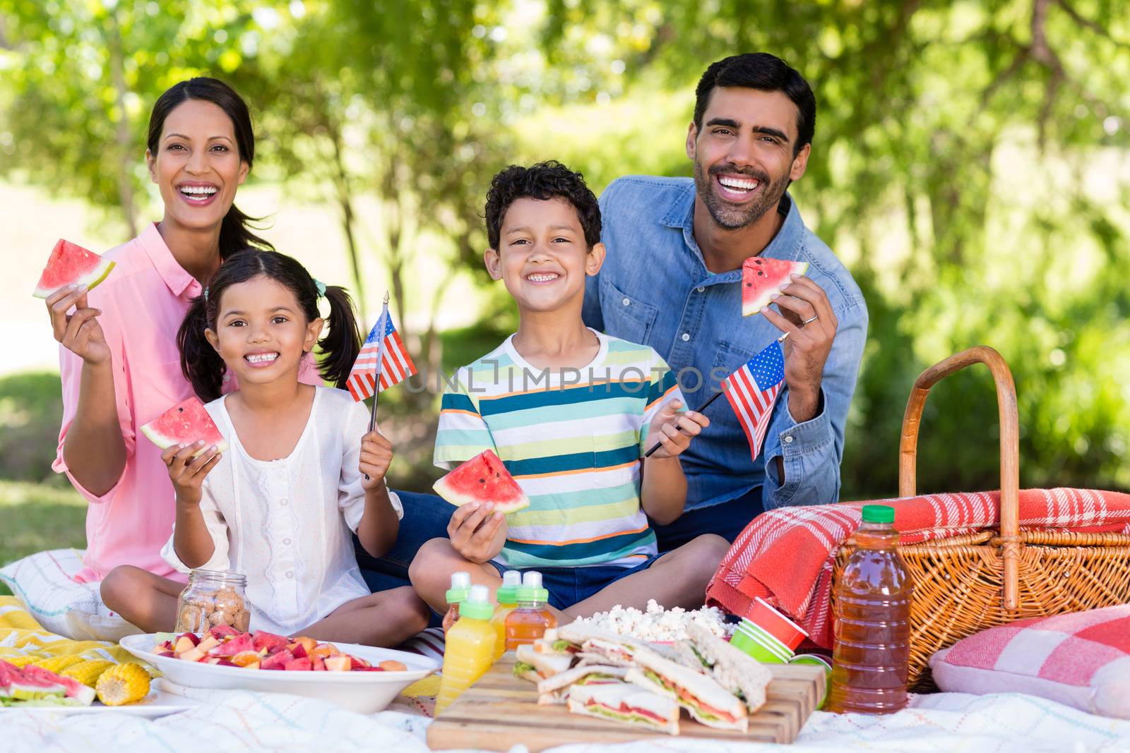 Portrait of family having breakfast in a park on a sunny day