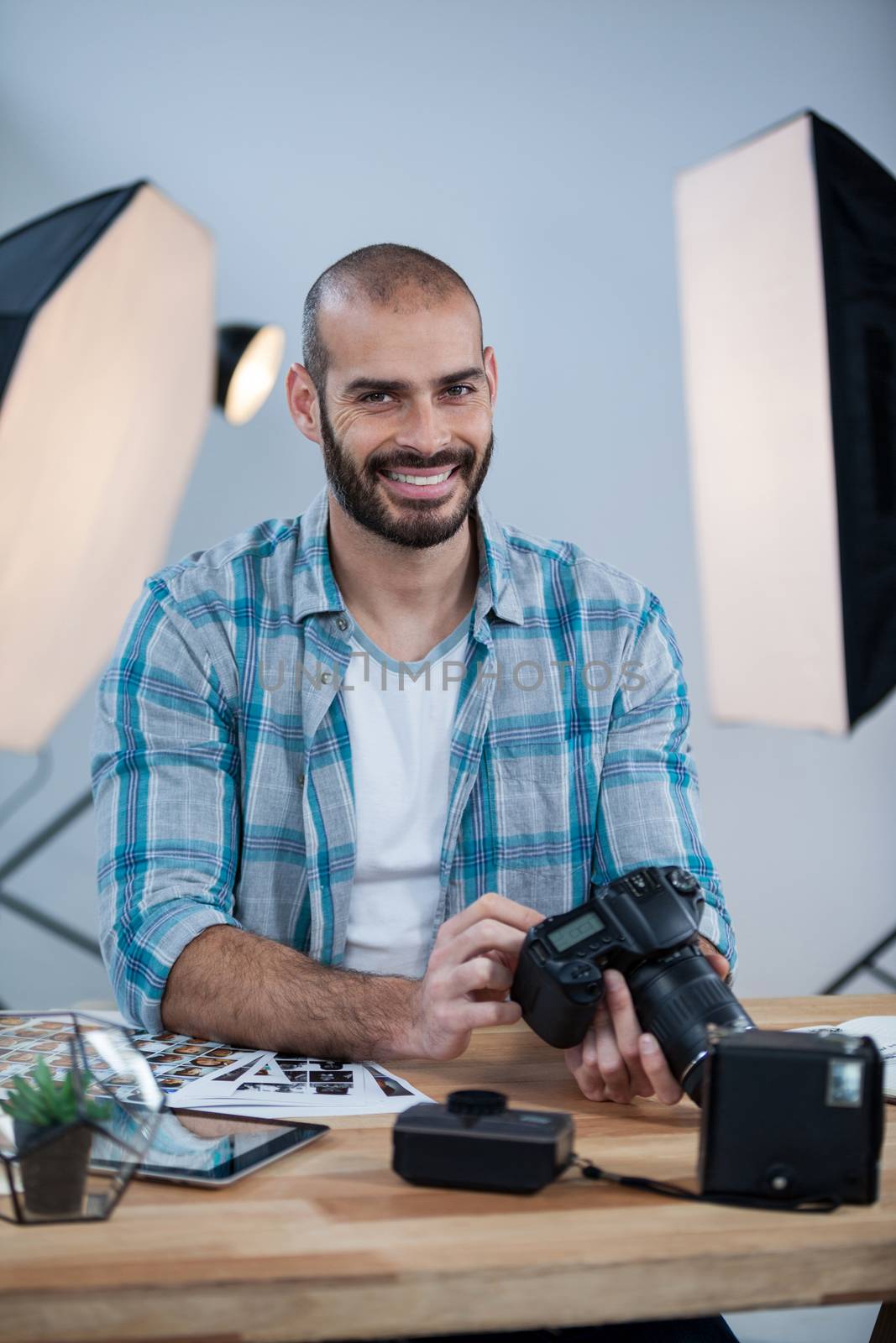 Portrait of photographer working over digital tablet at desk in studio