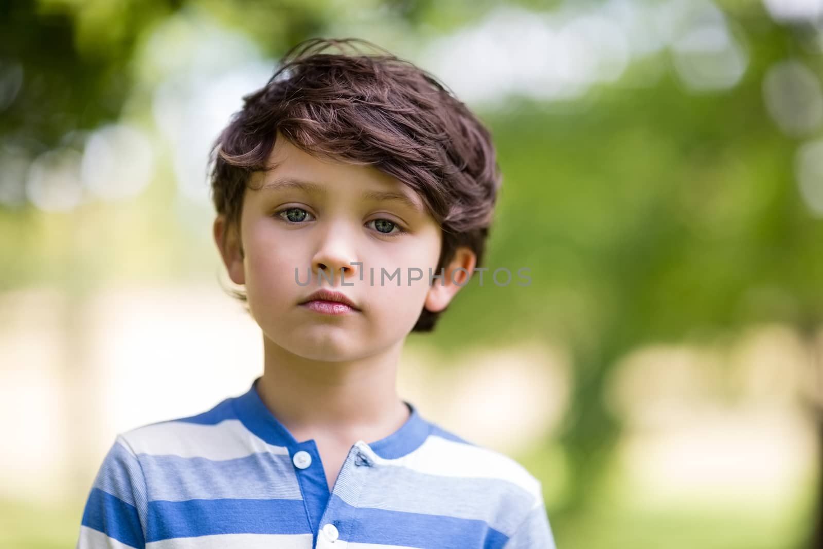 Portrait of innocent boy standing in park on a sunny day