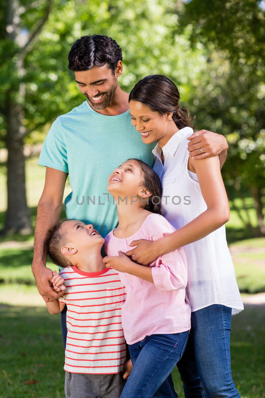 Happy family standing in park on a sunny day