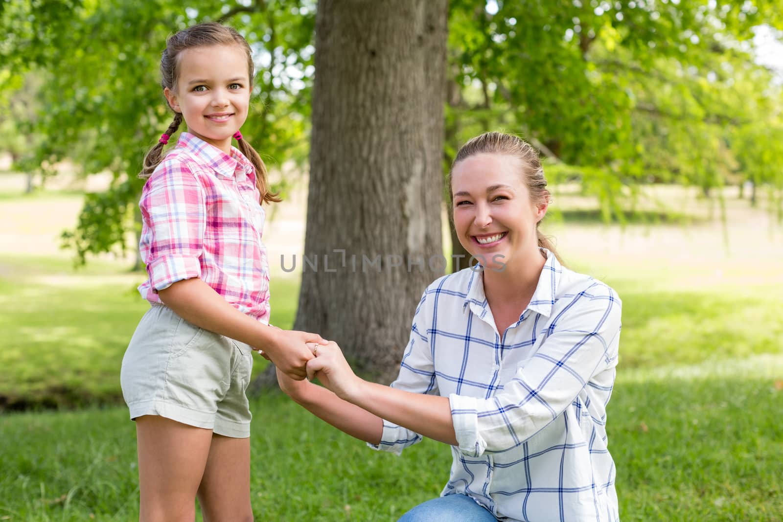 Portrait of a happy mother embracing her daughter in park