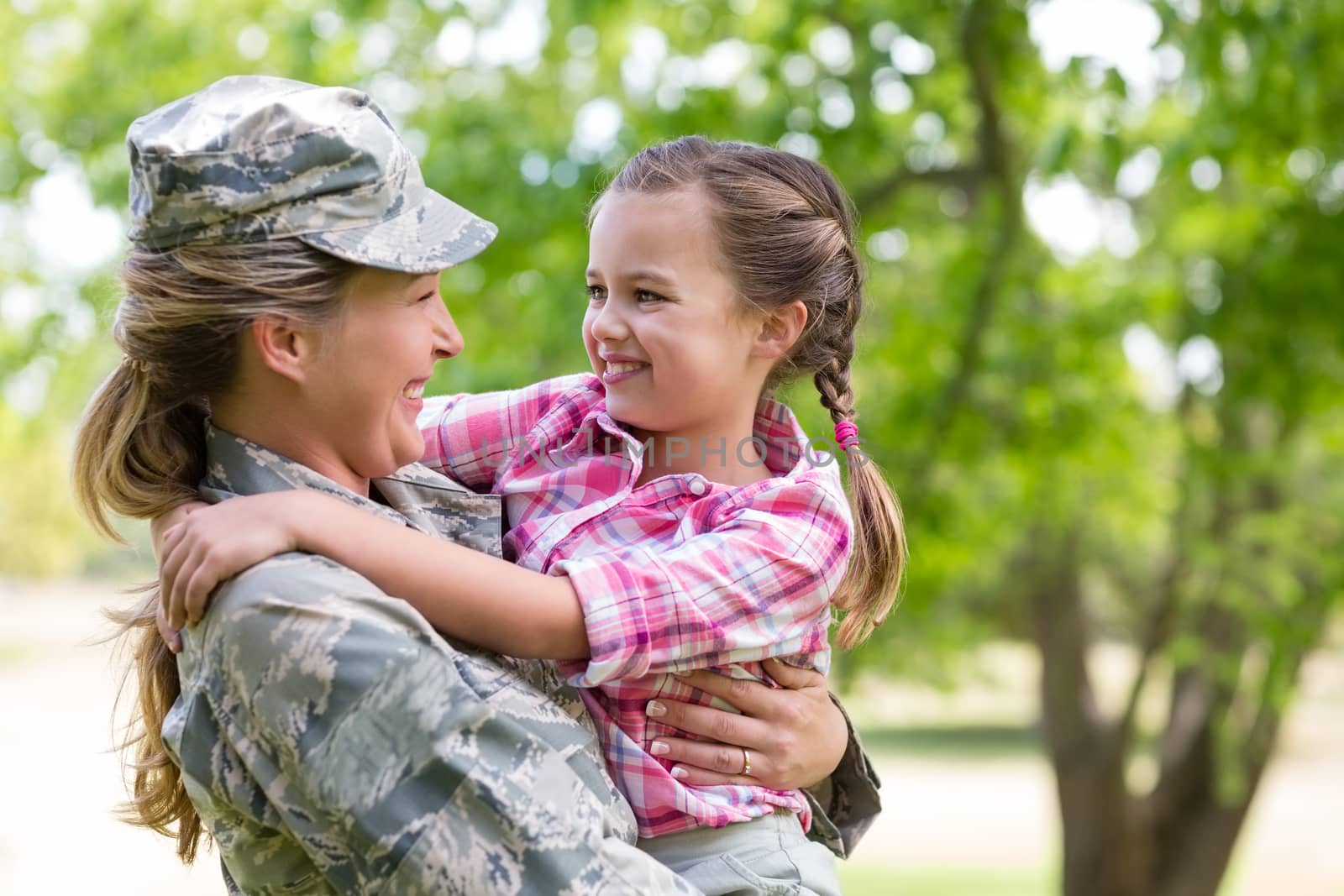 Happy female soldier with her daughter in park by Wavebreakmedia