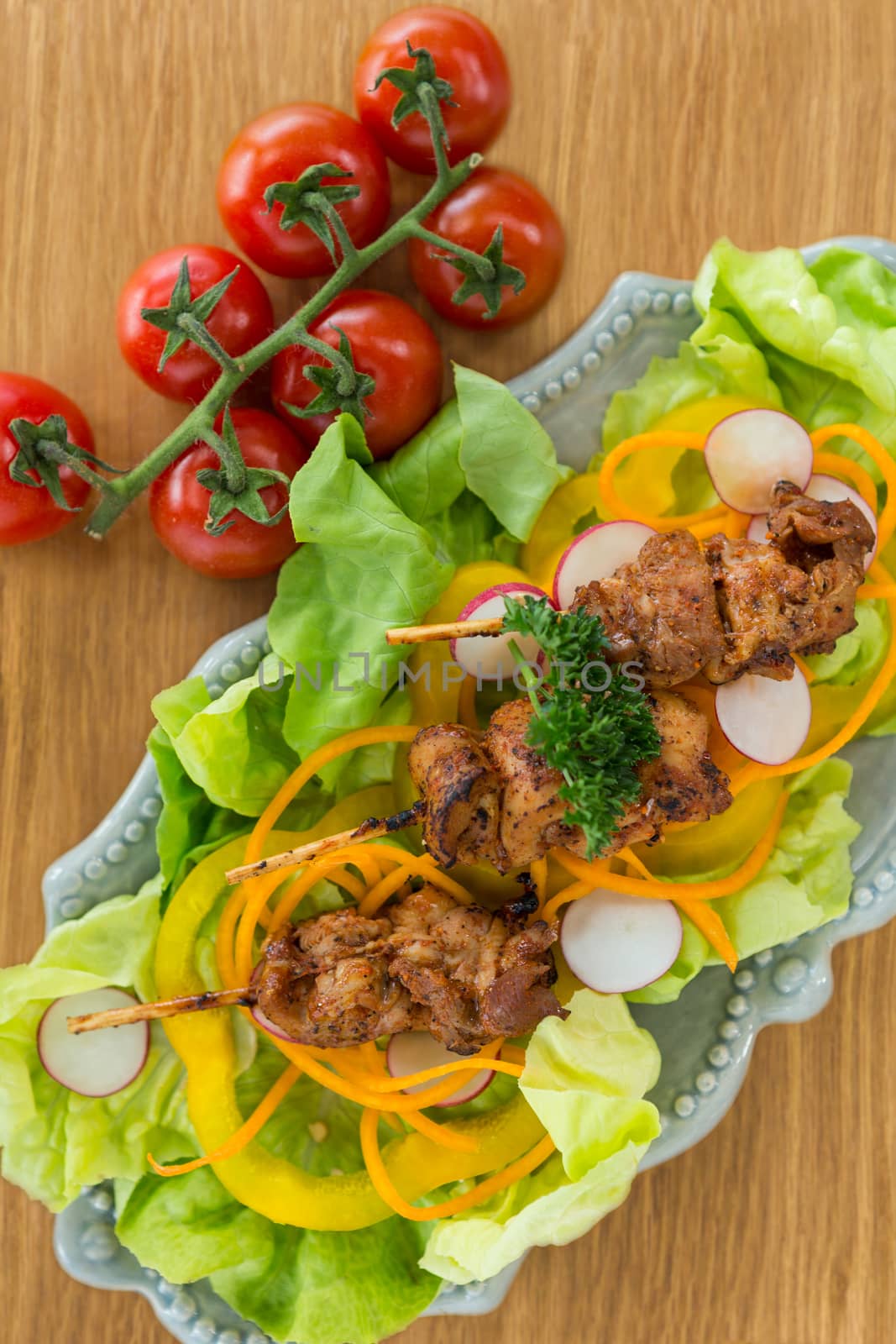 Vegetable salad and cherry tomato on wooden board by Wavebreakmedia