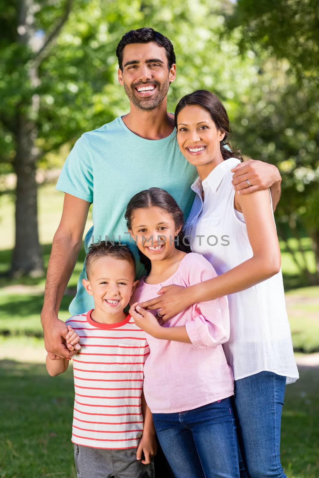 Portrait of happy family standing in park by Wavebreakmedia