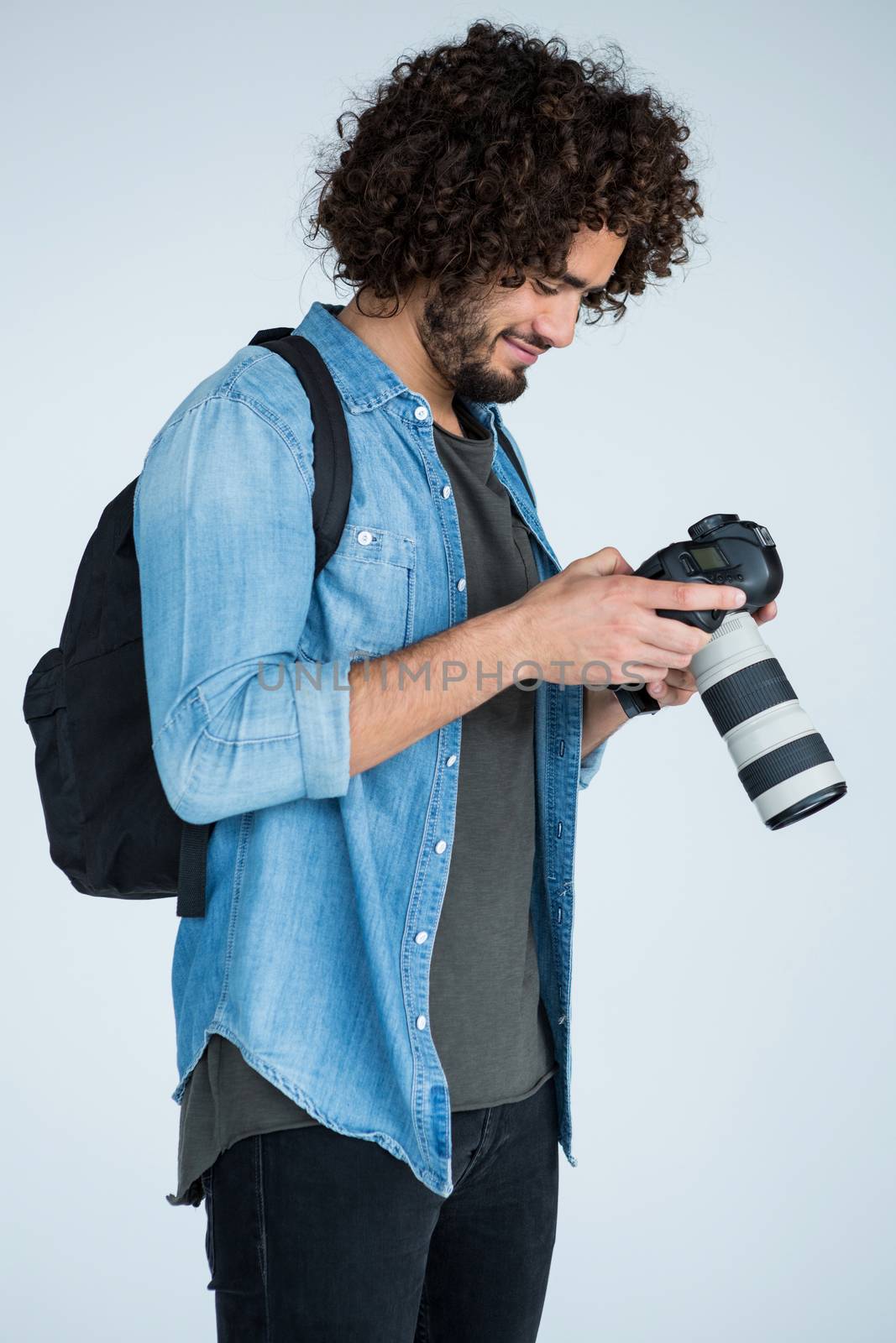 Male photographer reviewing captured photos in her digital camera at studio