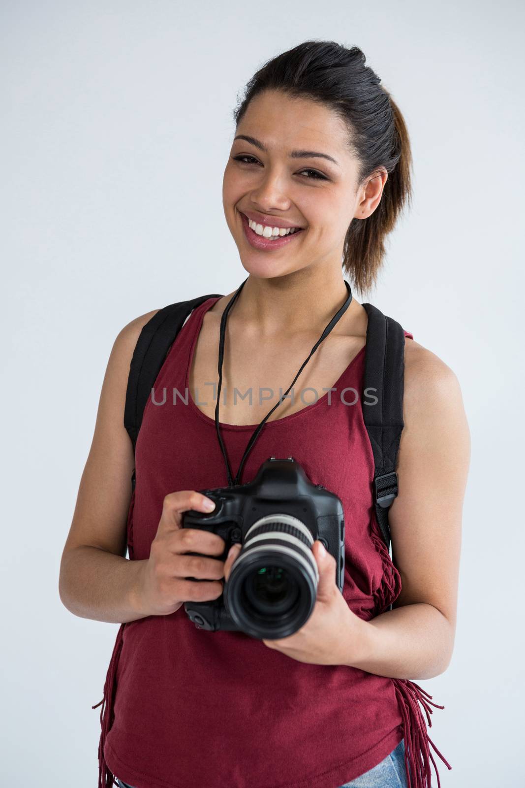 Portrait of happy female photographer standing in studio