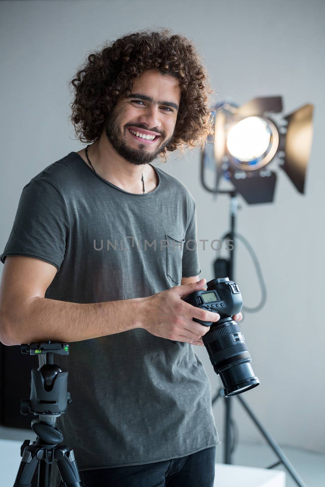 Happy male photographer standing in studio by Wavebreakmedia