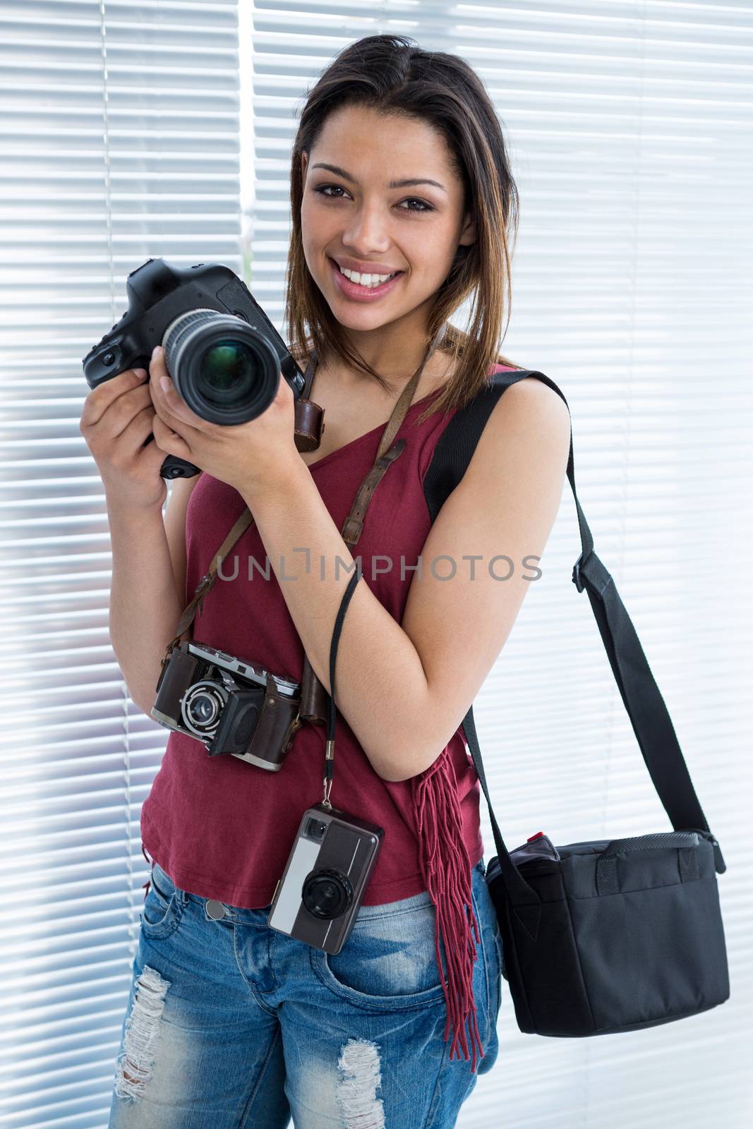 Happy female photographer standing in studio by Wavebreakmedia