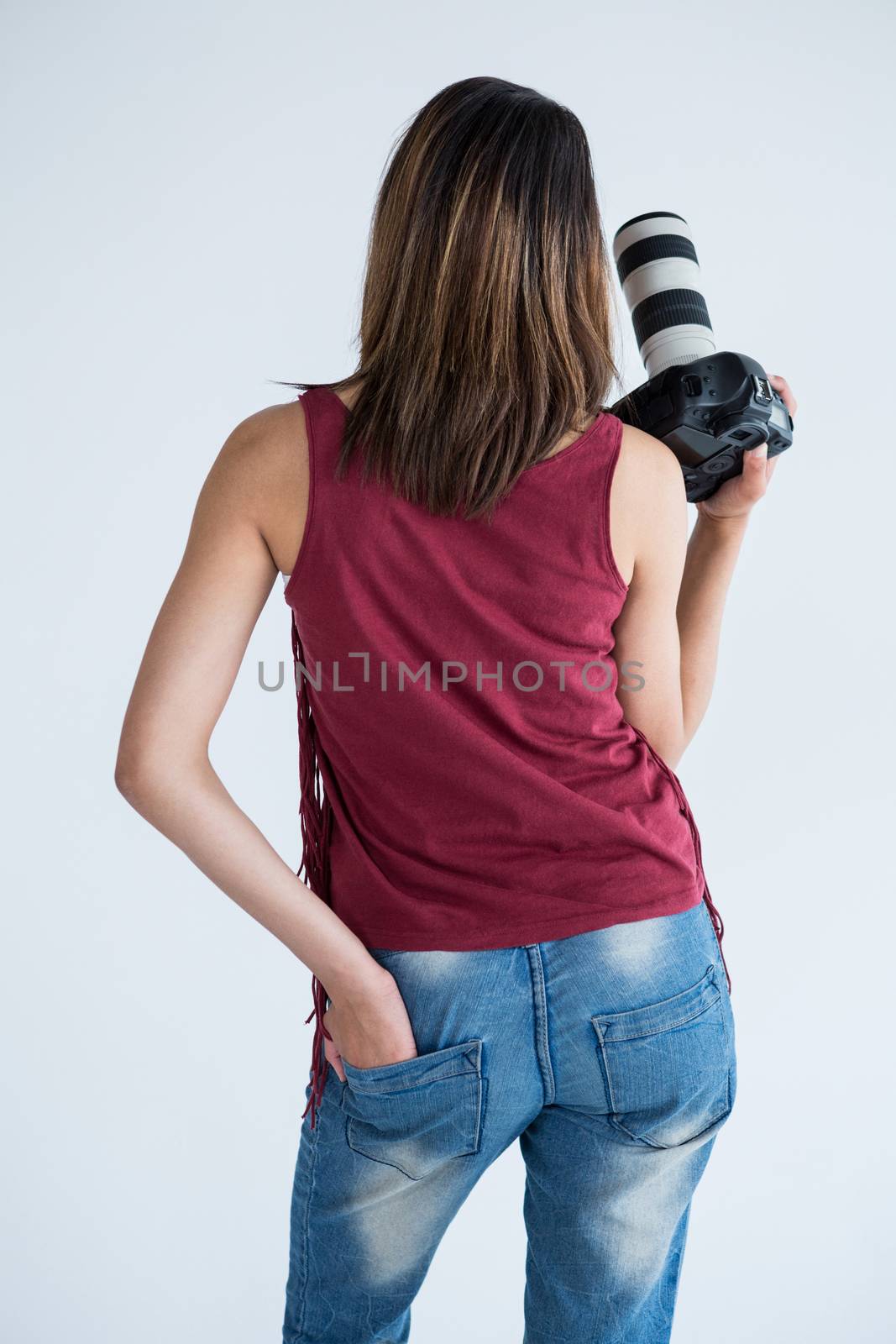Rear view of happy female photographer standing in studio