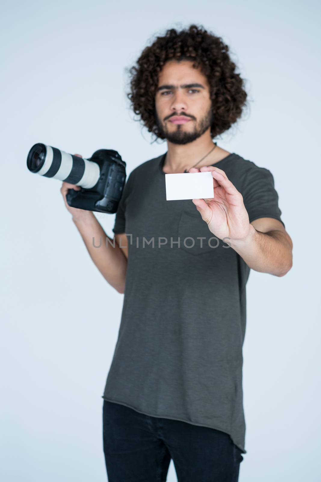 Portrait of male photographer showing visiting card in studio