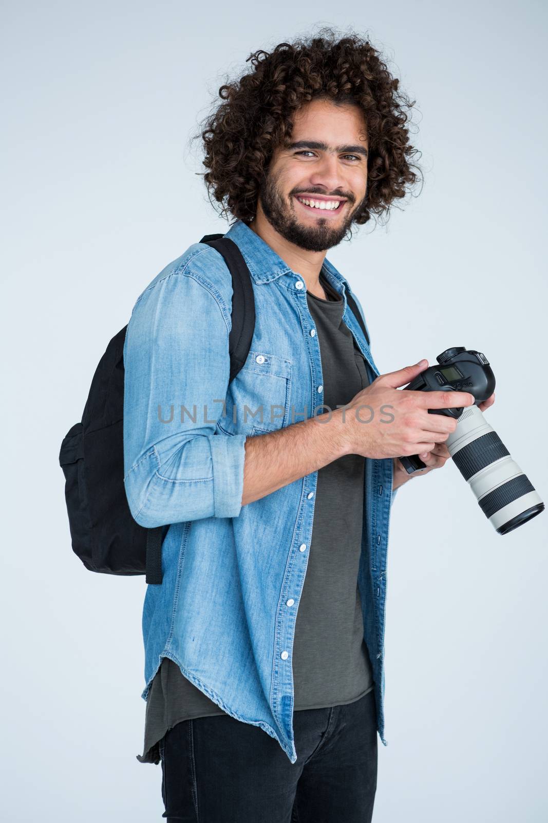 Portrait of happy photographer holding a camera in the studio